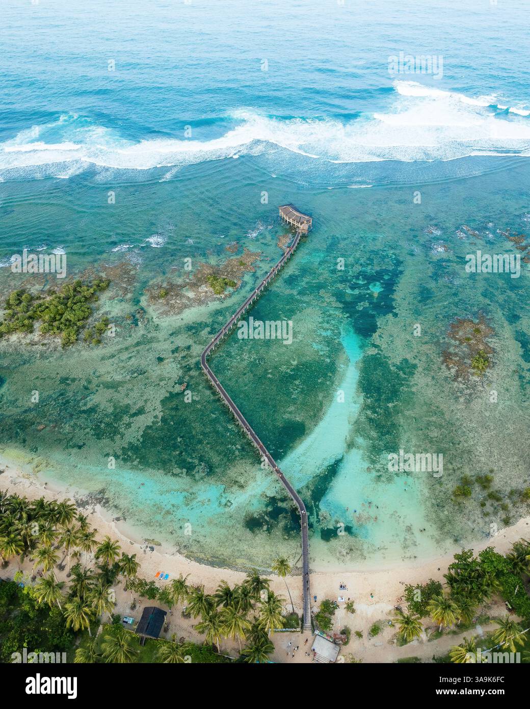 Atemberaubende Aussicht auf Cloud 9 Beach in Siargao aus der Vogelperspektive – Eine atemberaubende Strecke aus weißem Sand, türkisfarbenem Wasser und eine malerische Holzpromenade über dem Ozean Stockfoto