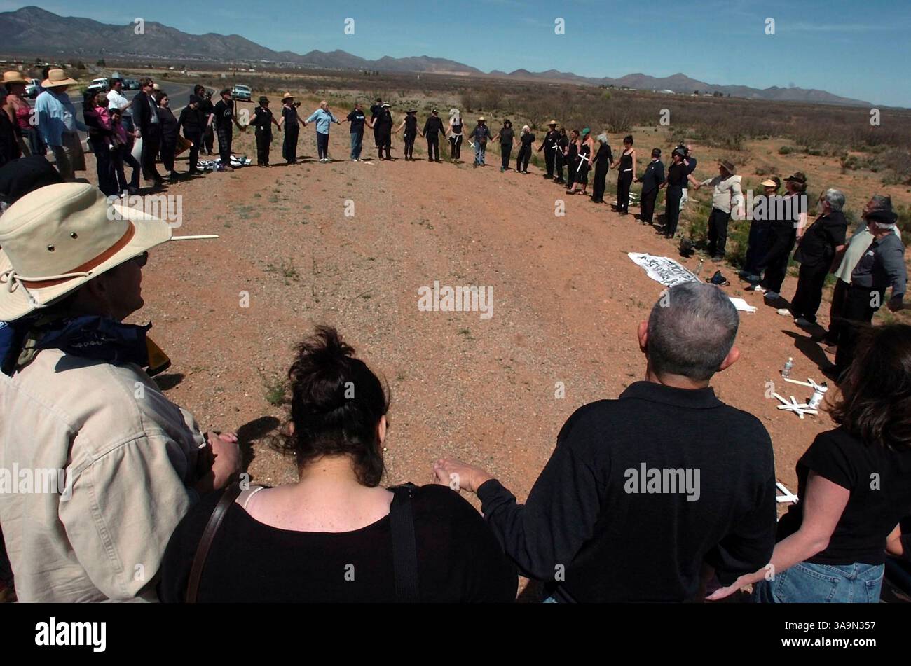 April 2005; Naco, AZ, USA; die Teilnehmer einer Wache „Women in Black“ schließen sich an die Hände und singen „Give Peace a Chance“, um die Mahnwache an der Grenze zwischen den USA und Mexiko am Samstag, den 2. April 2005 in Naco, AZ, zu beenden. Eine Reihe von „Unity Events“ ist als Gegenprotest gegen das Minuteman-Projekt geplant. Obligatorischer Credit: Foto von Bahram Mark Sobhani/San Antonio Express-News/ZUMA Press. (©) Copyright 2005 by San Antonio Express-News Stockfoto