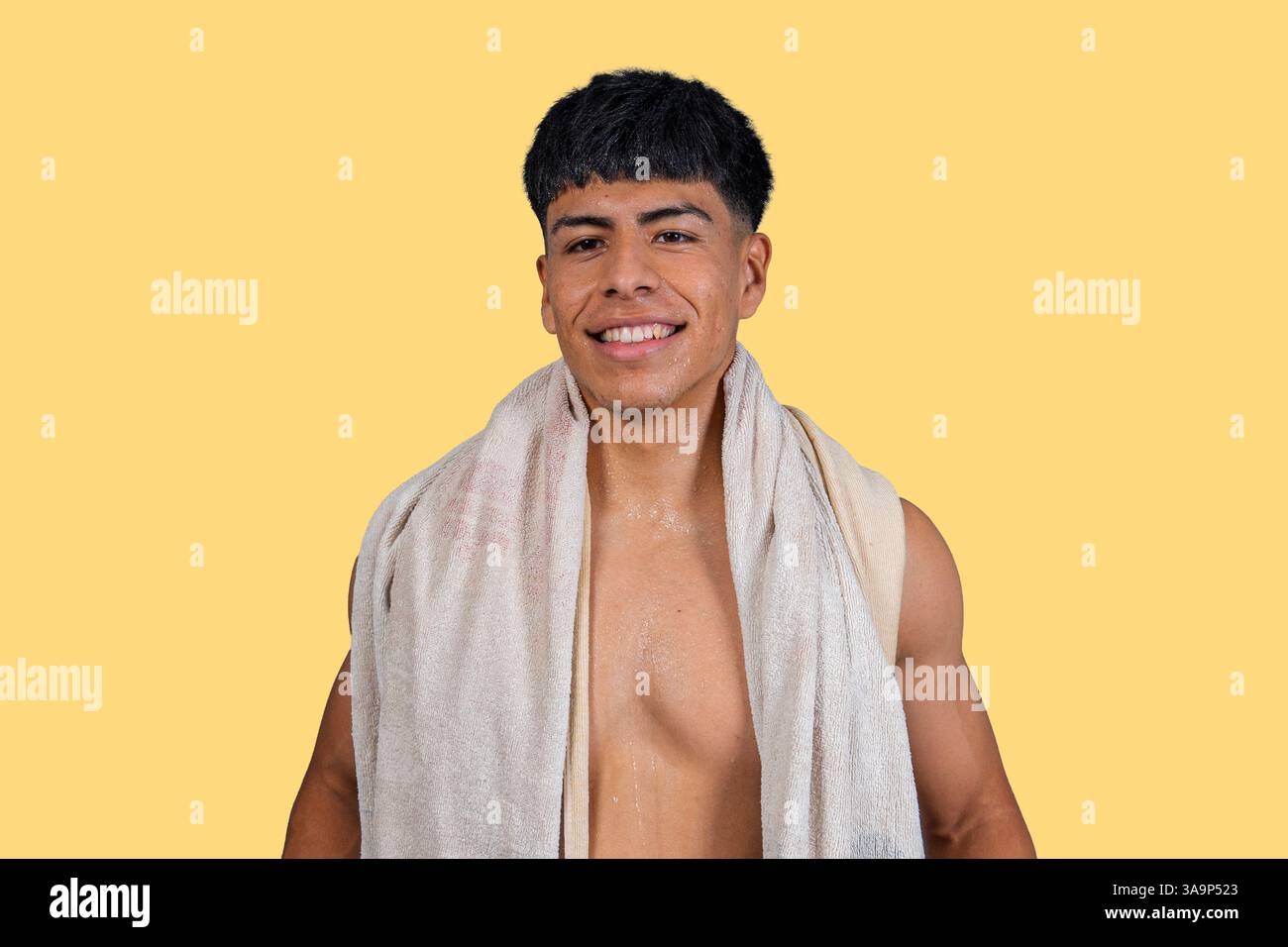 Glücklicher hispanischer Athlet, der nach einer erfrischenden Dusche lächelt und Hygiene und Wellness fördert Stockfoto
