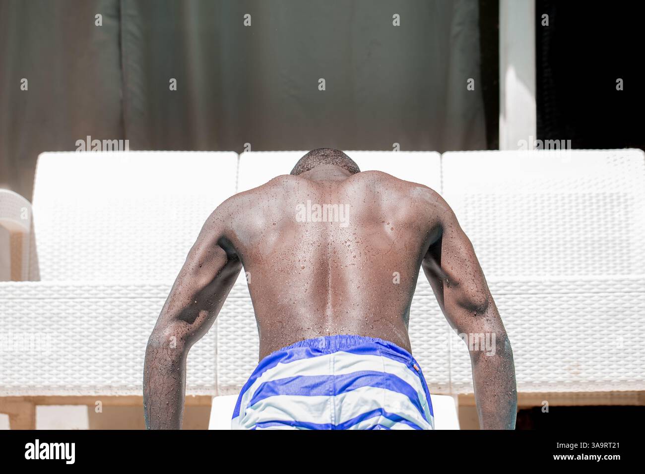 Muskulöser Rücken des afro-Nachfahrenden Mannes in Pool Stockfoto