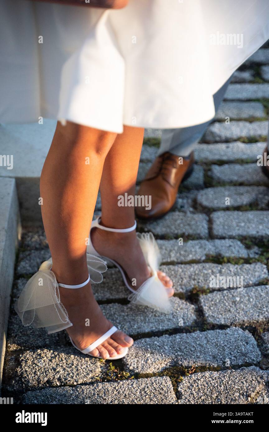 Elegante weiße Brautabsätze mit Tüllschleifen in sanftem goldenem Licht Stockfoto