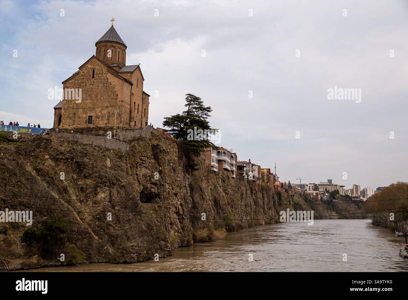 Tiflis, Georgien, 30. März 2025. Die Metekhi-Kirche und Wohngebäude auf Klippen entlang des Flusses Kura sind in der Altstadt, einem Touristenzentrum, zu sehen Stockfoto