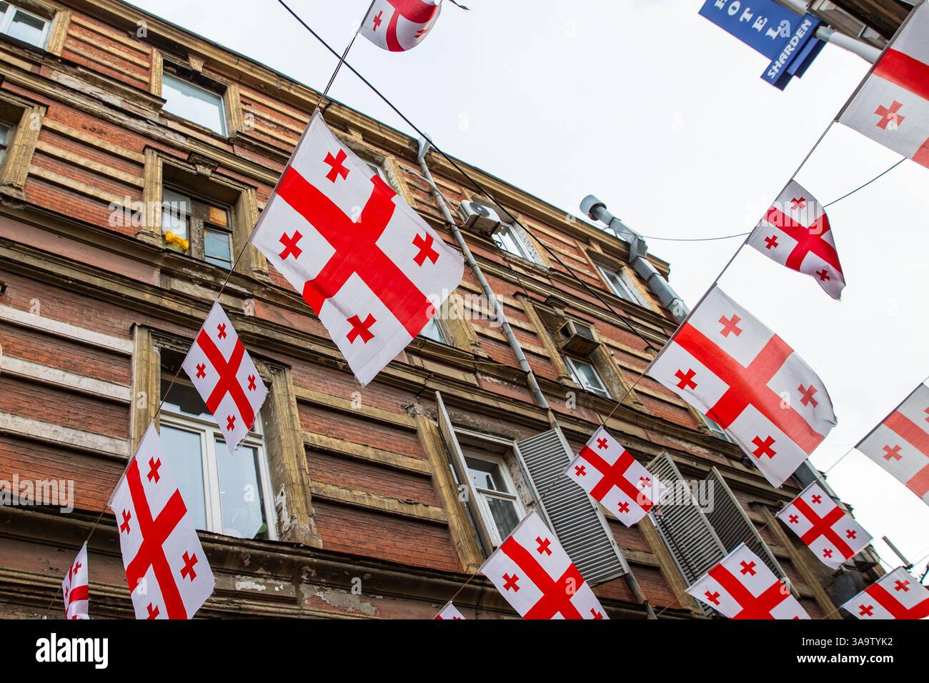 Georgische Nationalflaggen sind über einer Straße in der Altstadt zu sehen. Stockfoto