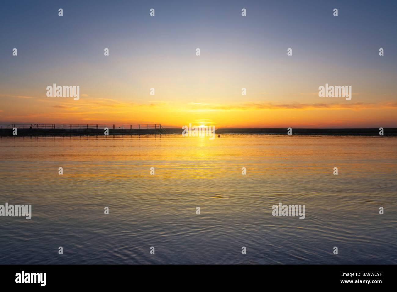 Der Sonnenuntergang über dem Meer mitten im Wellenbrechereingang. Lillatro, Rosignano Solvay, Provinz Livorno, Toskana, Italien Stockfoto