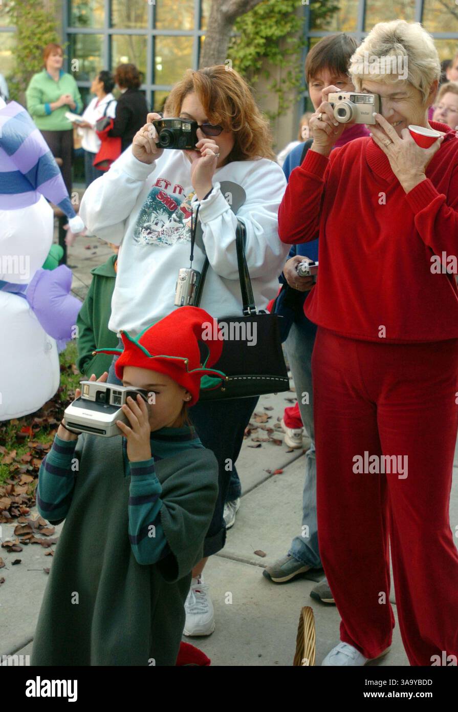 Als David, Brenden und Graciana Canda aus Antiochia mit dem Weihnachtsmann besuchten, wollten alle das besondere Ereignis aufnehmen, als Santas-Helfer Paige Rodrigues, 12, ein Poloroid macht, Mutter Shari Canda (cq) aus Antiochia und Großmutter Linda Sager aus Clayton am Samstag, 11. Dezember 2004, Familienfotos in der Clayton-Bibliothek machen Die Kinder besuchten auch mit Mrs. Claus, hatten Kekse, Zuckerstangen und ein Spielzeug. (Contra Costa Times/Susan Tripp Pollard)/ZUMA Press Stockfoto