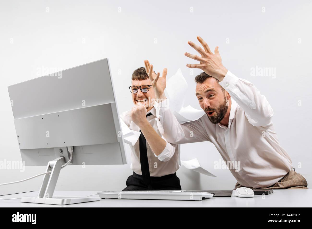 Zwei Geschäftsleute im Büro freuen sich und zeigen Begeisterung für die geleistete Arbeit. Das Konzept eines erfolgreichen Online-Geschäfts Stockfoto