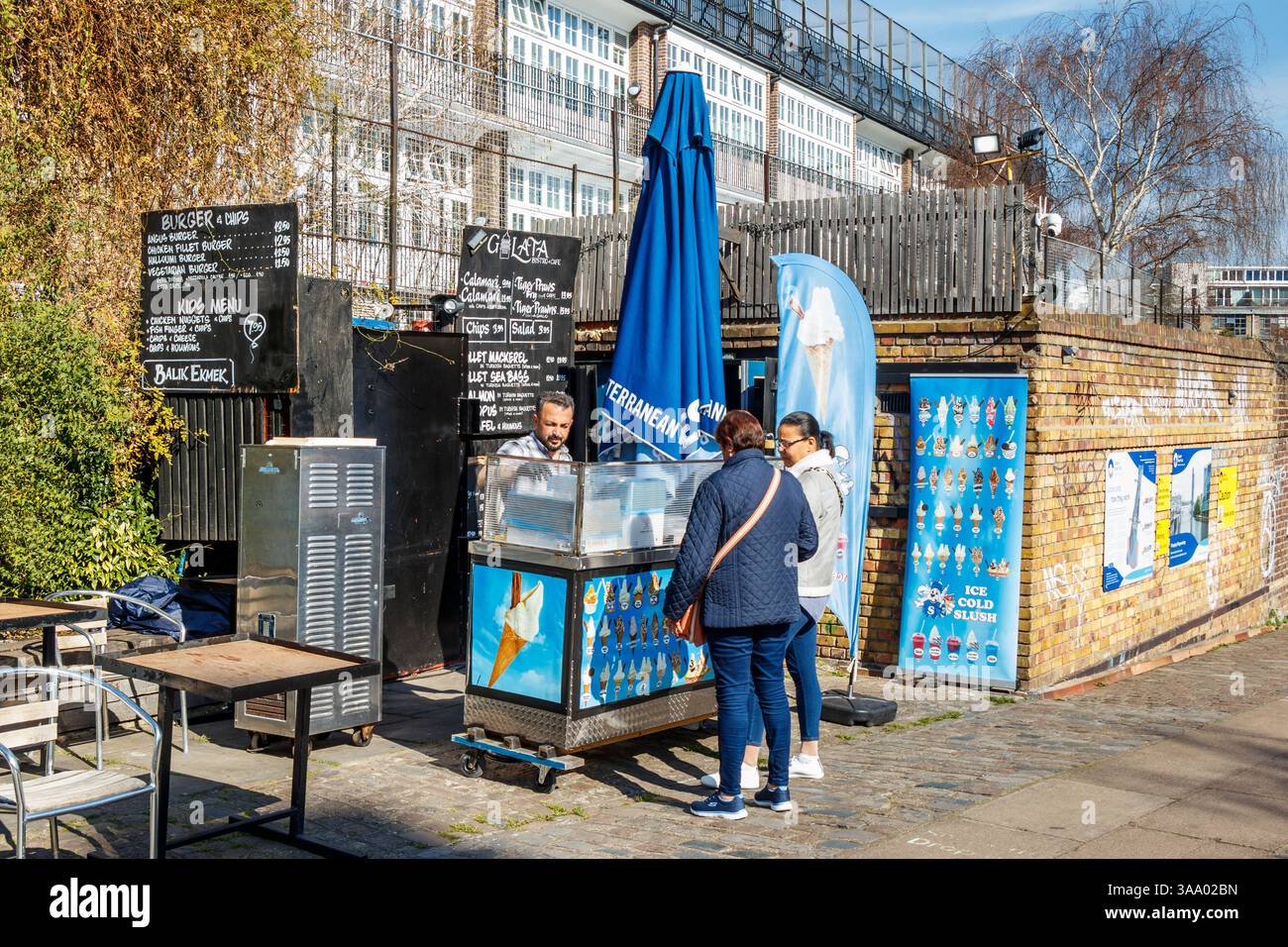 Bei warmem Frühlingswetter kaufen die Menschen Eis am City Road Lock (Nr. 5) am Regent's Canal, Islington, London, Großbritannien Stockfoto