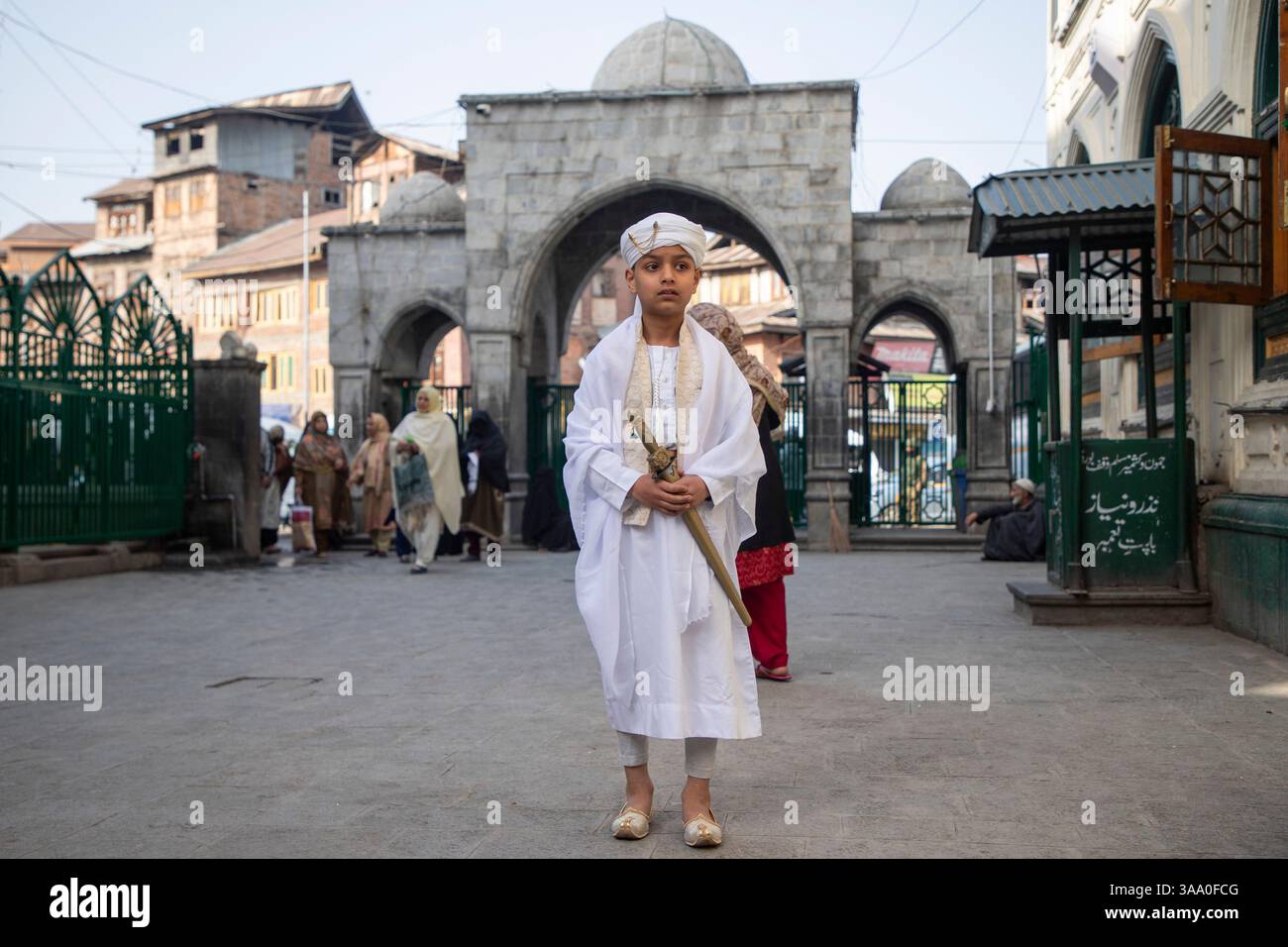 Srinagar, Indien. 31. März 2025. Kaschmirs muslimischer Junge posiert für ein Bild, während Gläubige Eid-al-Fitr Gebete am Schrein des muslimischen Predigers und des Sufi-heiligen Scheich Syed Abdul Qadir Jeelani in Srinagar anbieten. Das EID-al-Fitr-Festival ist das Ende des heiligen Fastenmonats Ramadan. (Foto: Faisal Bashir/SOPA Images/SIPA USA) Credit: SIPA USA/Alamy Live News Stockfoto
