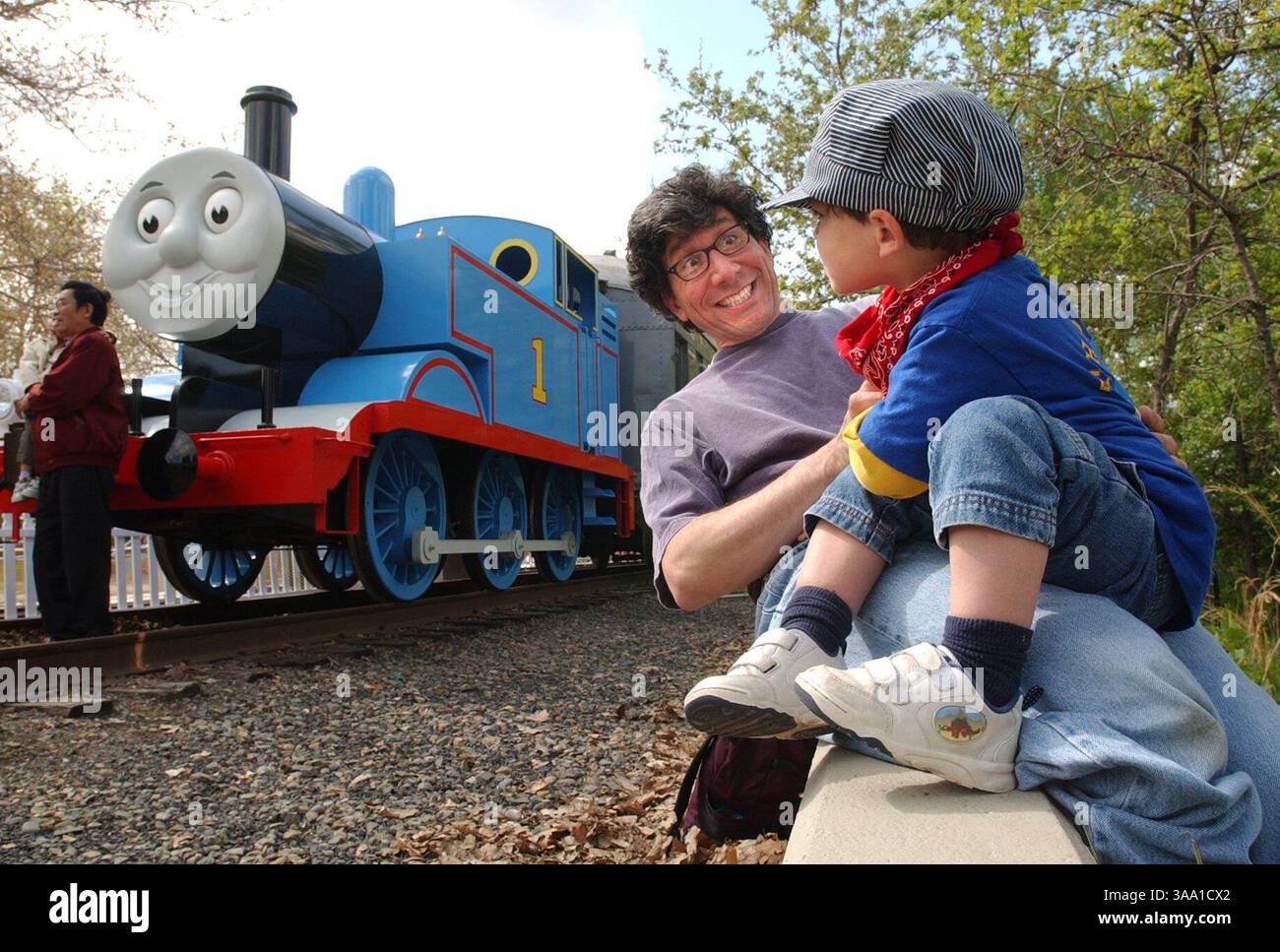 -- Mittwoch, 10. April 2002, Sacramento, Kalifornien -- Michael Mitrani, Zweiter von rechts, aus San Francisco versucht, ein Lächeln von seinem zweijährigen Sohn Sam zu bekommen, richtig, als sie sehen, wie Thomas die Panzermaschine am Mittwochmorgen einen Halt im California State Railroad Museum in Old Sacramento macht. Obwohl die Tickets für die fünftägige Veranstaltung ausverkauft sind, kehrt „Thomas“ vom 4. Bis 8. Dezember 2002 zurück. (Sacramento Bee / Hector Amezcua) die Sacramento Bee / ZUMA Press Stockfoto