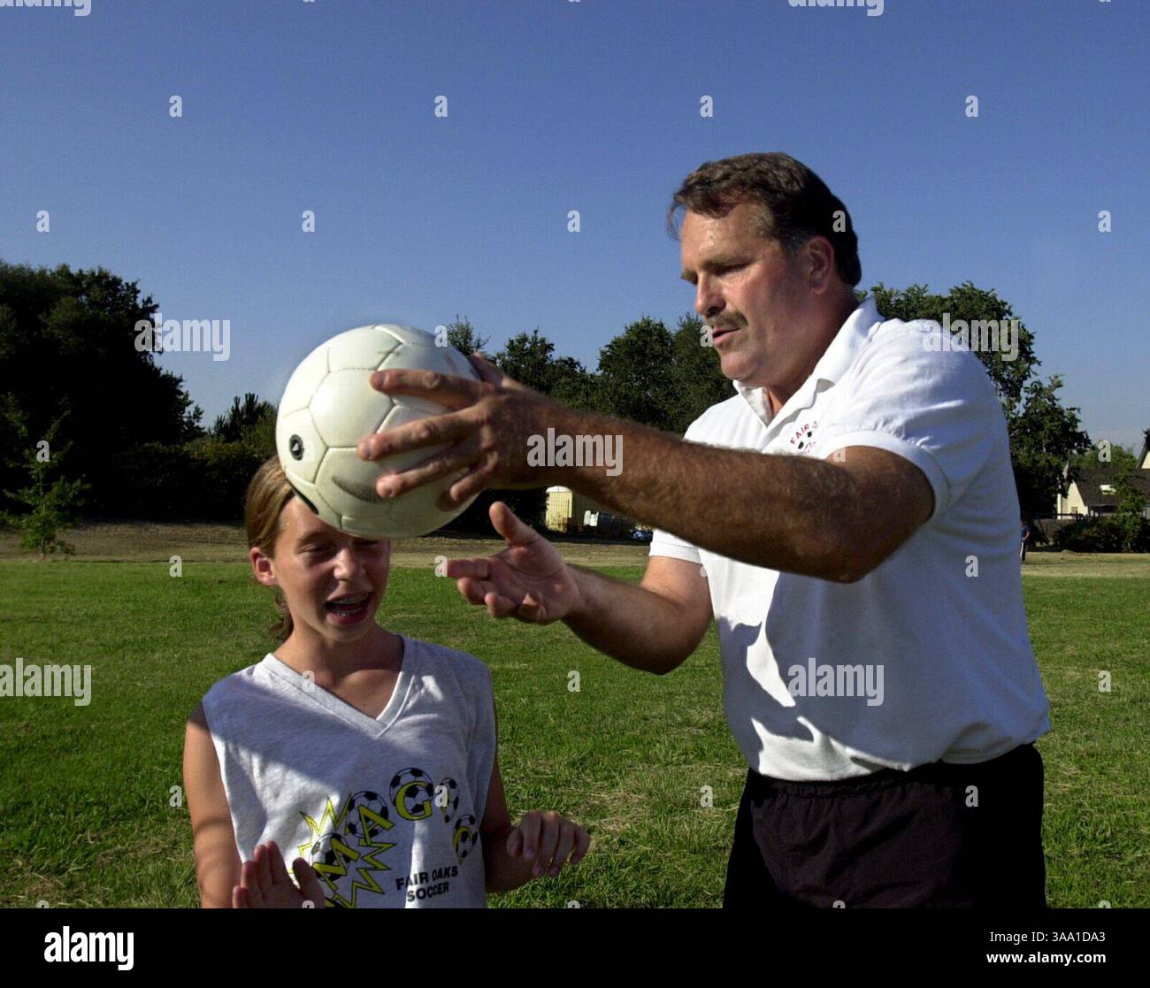 Fritz Hoffman ist Fußballtrainer des Fair Oaks Magic Fußballvereins. Er arbeitet zwei Tage die Woche mit dem Team zusammen und koordiniert andere Aktivitäten in der Liga. Am Donnerstag, dem 1. August 2002, arbeitete er mit Kate Jones 13 an der Technik, den Ball zu führen. Sacramento Bee/Jay Mather für Over and Beyond column./ZUMA Press Stockfoto