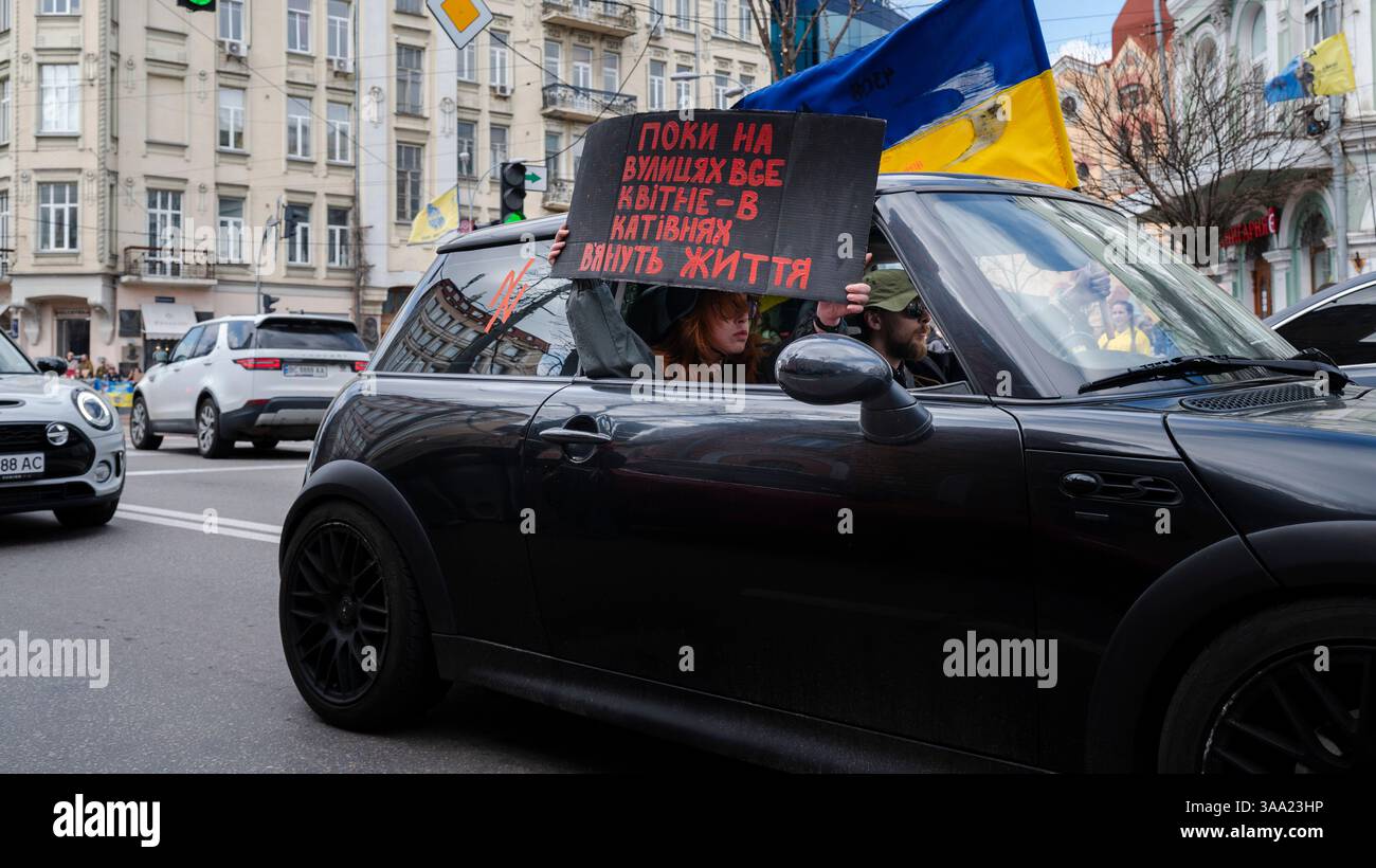 Kiew, Ukraine - 30. März 2025: Aktivisten versammeln sich zur Unterstützung des Asow-Bataillons inmitten des anhaltenden Konflikts, halten Schilder, schwenken Fahnen und fahren durch die Straßen der Stadt. Stockfoto