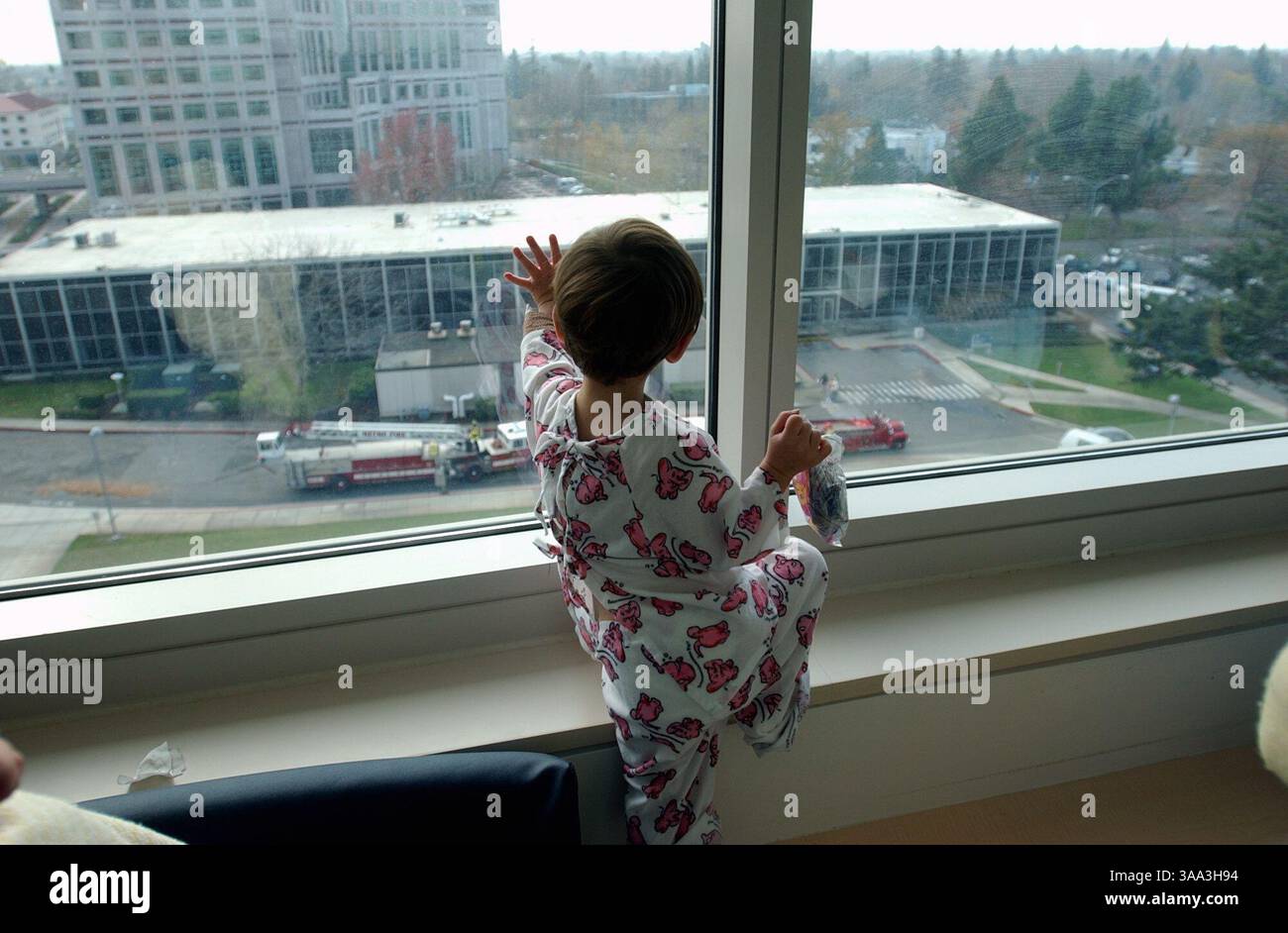 Der zweijährige Julian Lawson (cq) winkt dem Feuerwehrmann aus dem 7. Stock des UC Davis Medical Center Kinderflügels zu. Feuerwehrleute von Station 109 in Carmichael, Kalifornien, und Cargo Largo, lieferten mehr als 300 Spielzeug an die Kinder im Krankenhaus Donnerstag Morgen. Sacramento Bee Foto von Jose Luis Villegas 6. Dezember 2001 Sacramento Bee/ZUMA Press Stockfoto