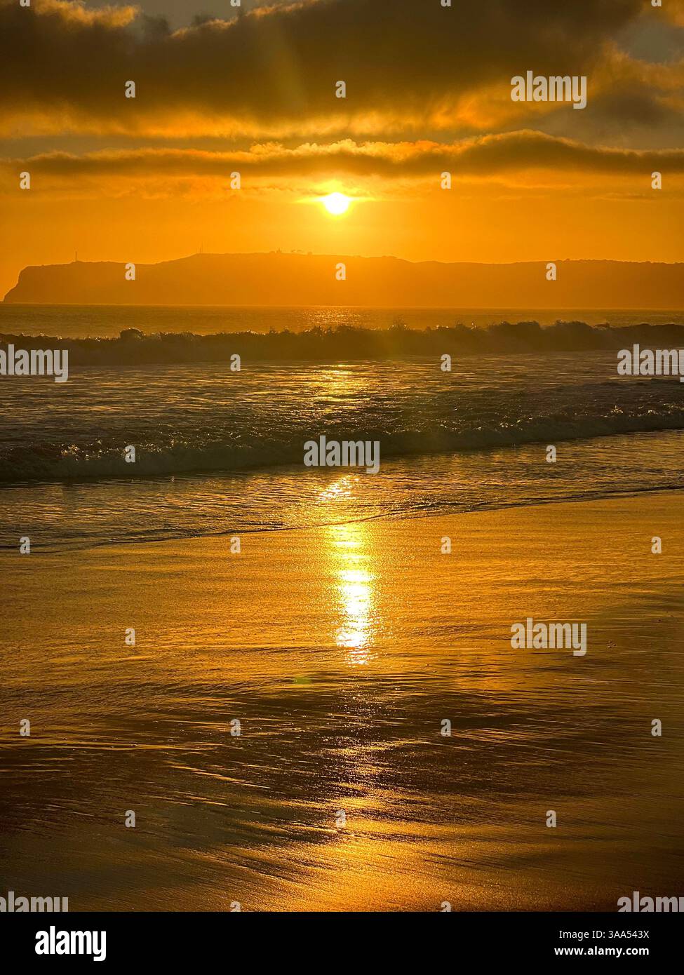 Wunderschöner Sonnenuntergang an der Küste Kaliforniens am Strand, mit leuchtenden Farben, die den Himmel erleuchten und sich auf dem Meer spiegeln. - Smartphone-aufgenommenes Stockfoto