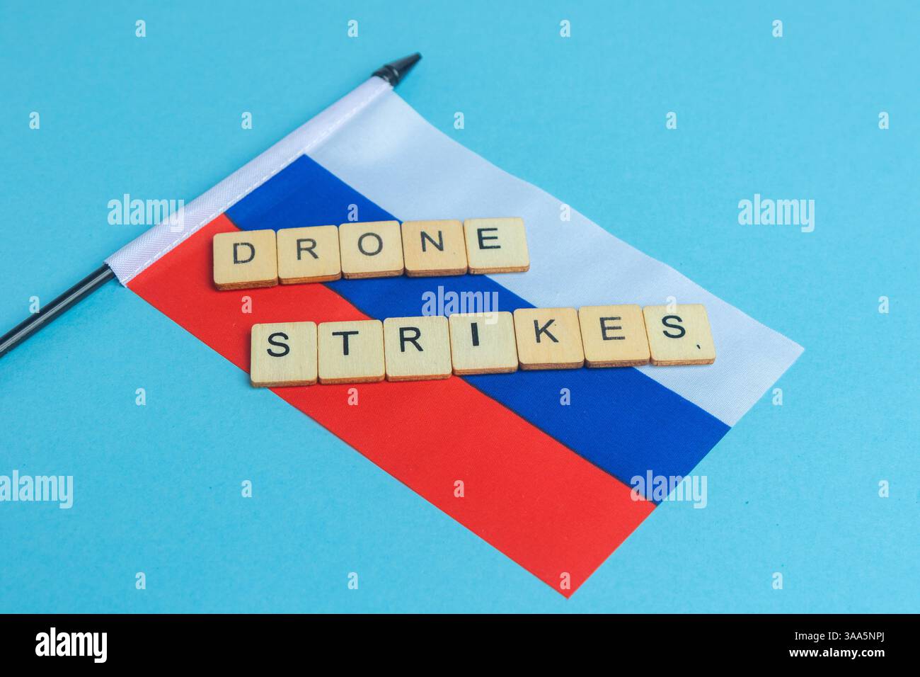 Die Nationalflagge der Russischen Föderation, zusammen mit einem Schild mit der Aufschrift Drohnenangriffe Stockfoto