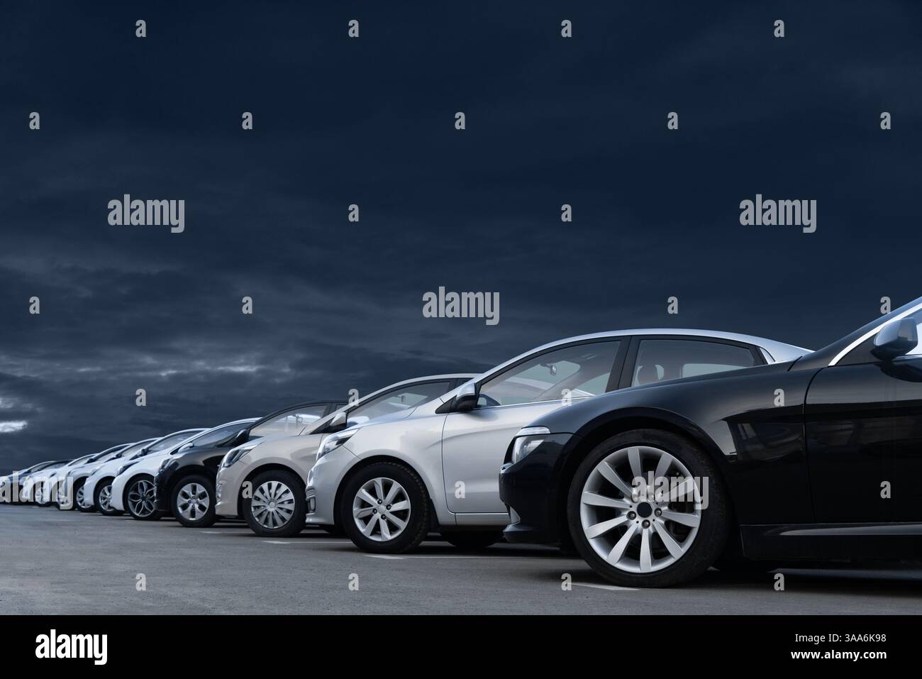 Autos vor dramatischem Himmel. Ein Symbol der Krise in der Automobilindustrie. Stockfoto