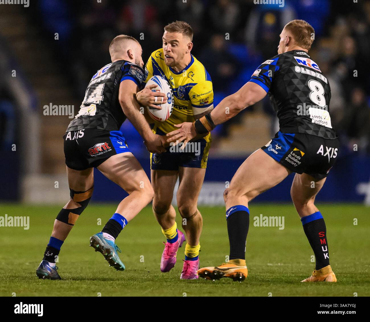 WARRINGTON, ENGLAND – 28. MÄRZ 2025: Matt Dufty von Warrington Wolves wird von Jarrod O’Connor von Leeds Rhinos während der Betfred Super League Ro bekämpft Stockfoto