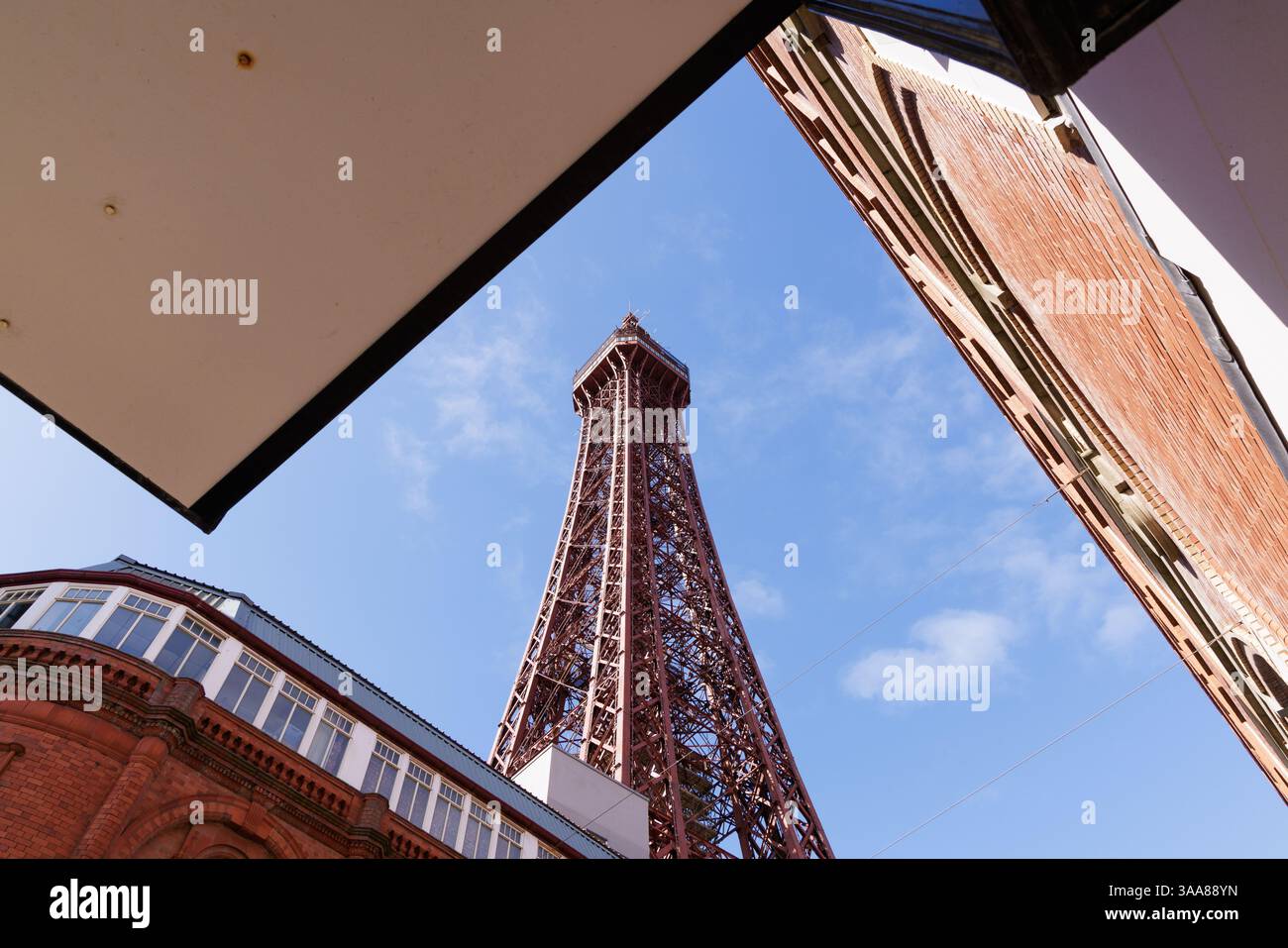 Blackpool, Lancashire, Großbritannien: Der Blackpool Tower wird von der Bank Hey Street aus gesehen und umliegende Gebäude bilden einen Rahmen. Stockfoto
