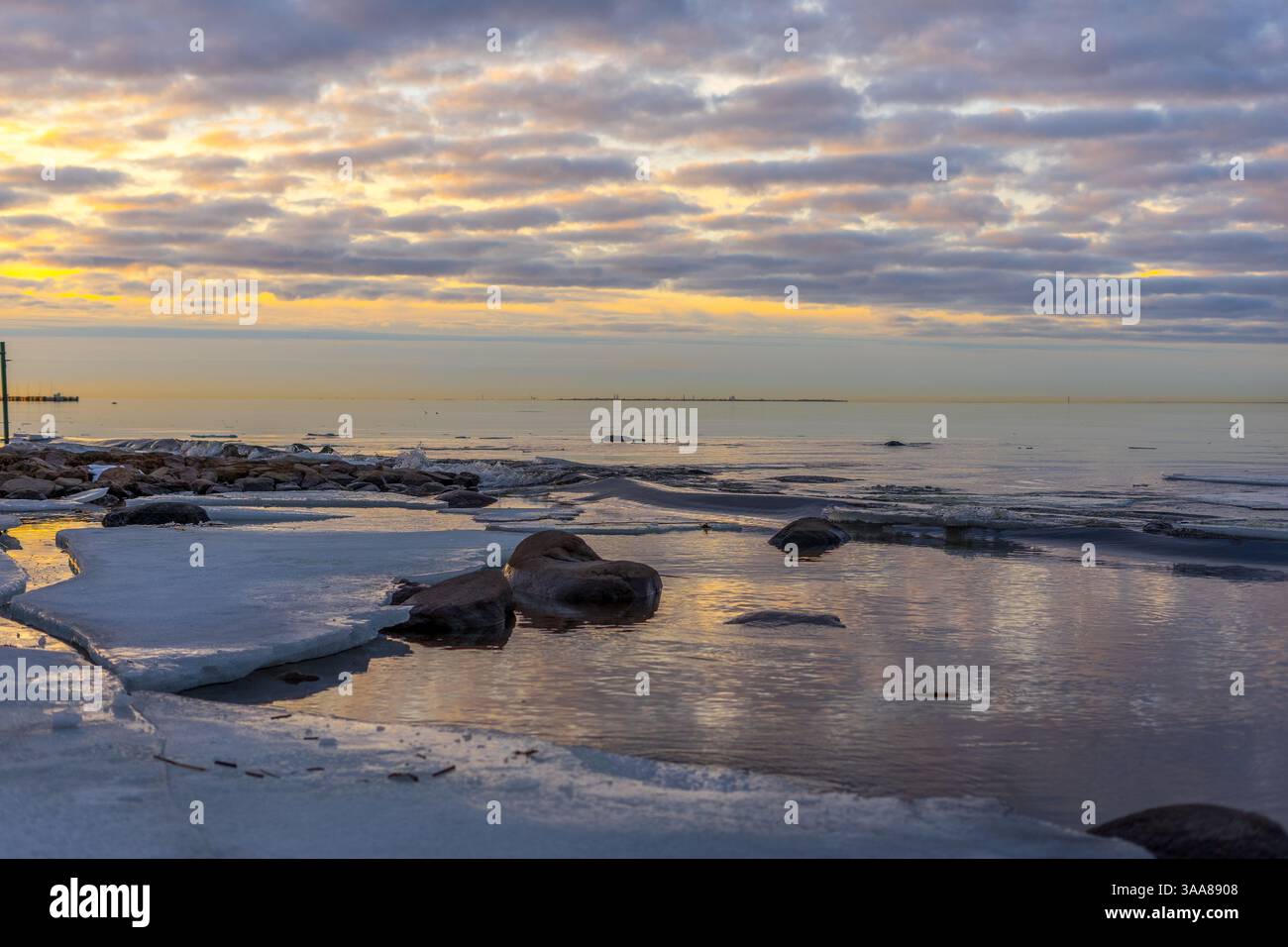 Sonnenuntergang über dem eisigen Meer mit wunderschönen Wolken Stockfoto