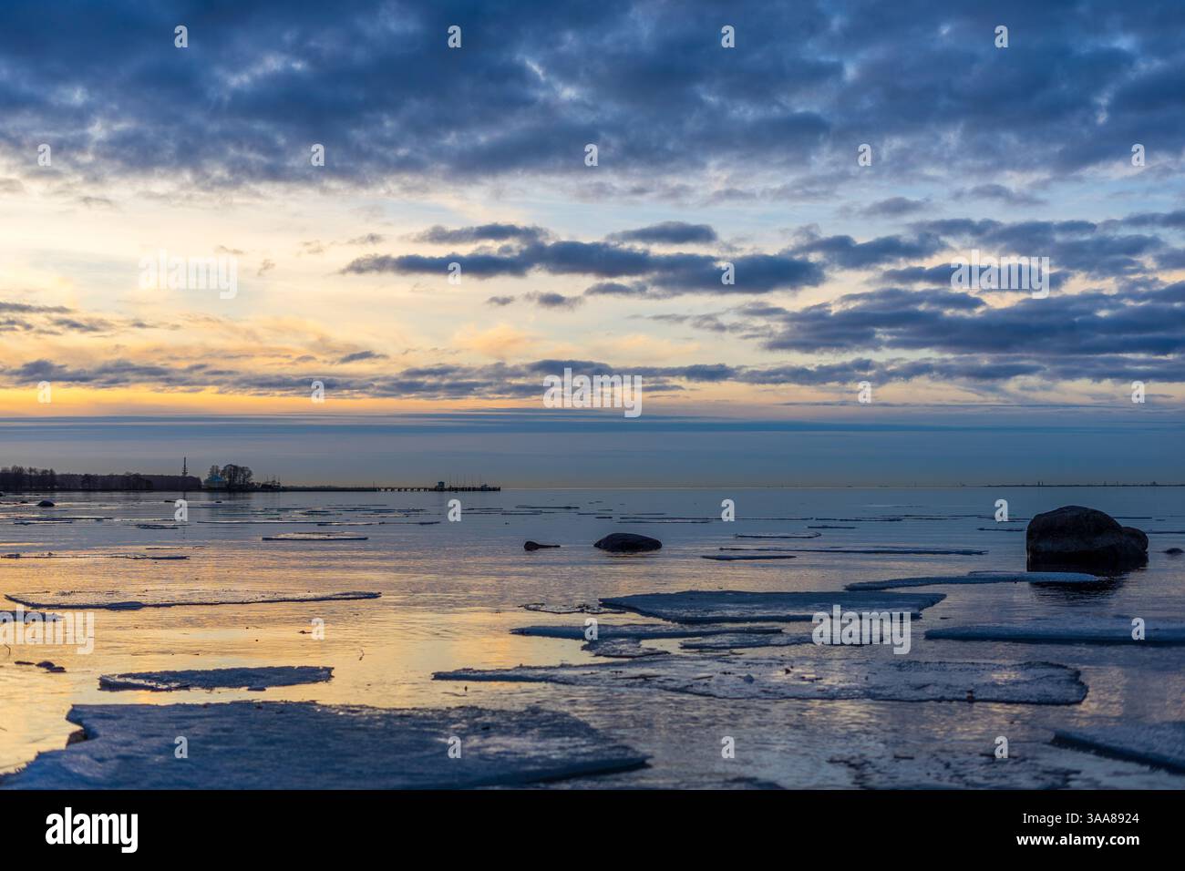 Sonnenuntergang über dem eisigen Meer mit wunderschönen Wolken Stockfoto