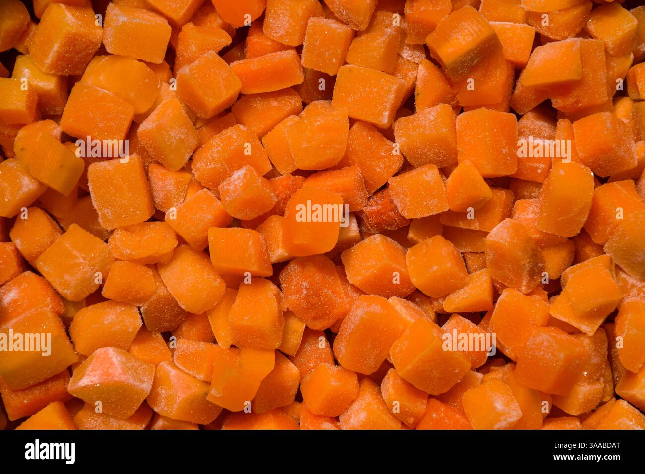 Grob in Würfel geschnitten, gefrorener Butternusskürbis Hintergrund Stockfoto