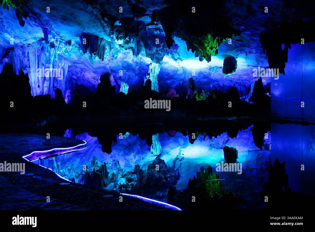 Vollständiger Blick auf die blau beleuchtete Wand und Reflexion in der Schilfflötenhöhle (Guilin, China) - 7. September 2024 Stockfoto