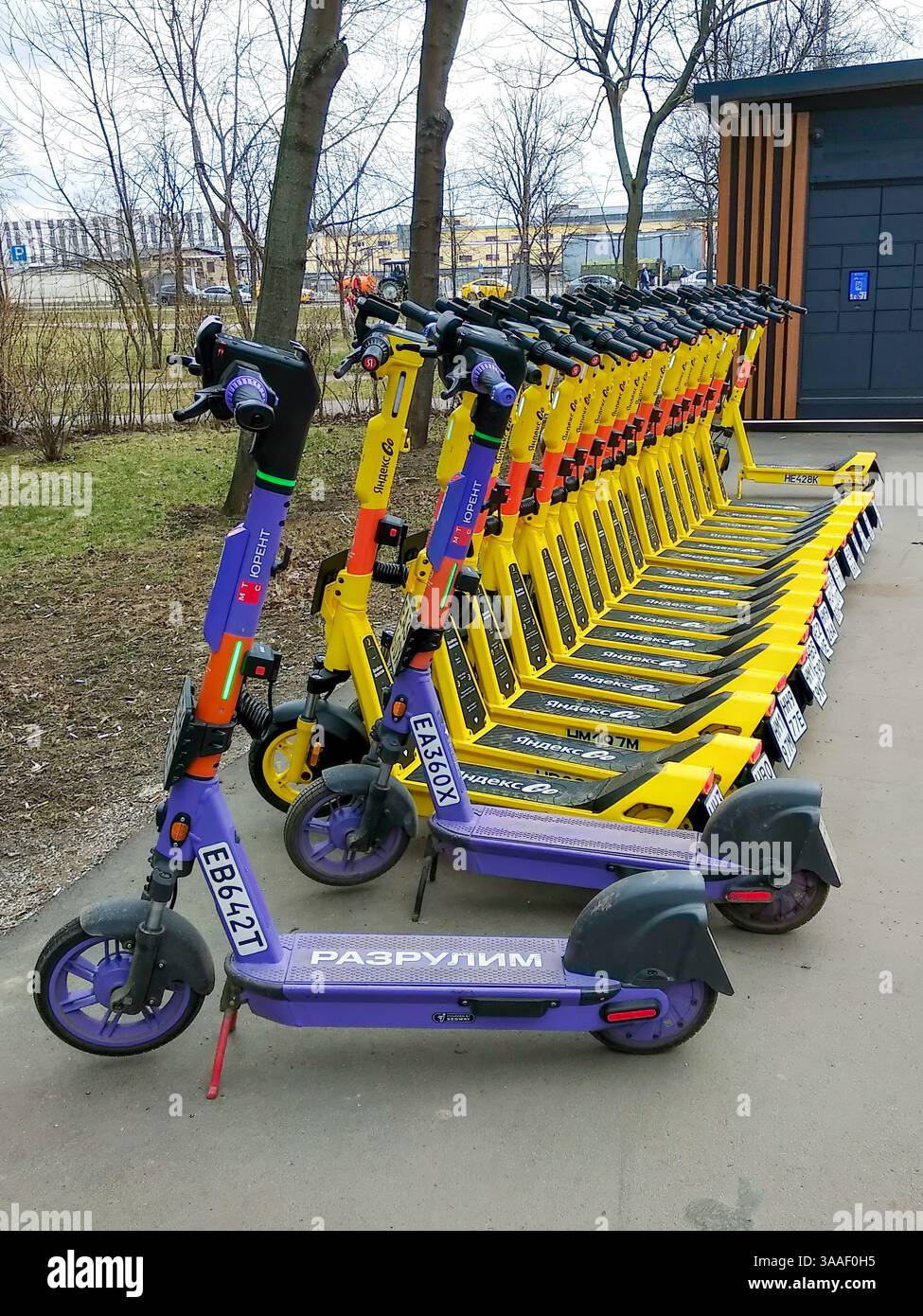 Moskau, Russland - 30. März 2025: Eine Reihe von Elektrorollern von verschiedenen Vermietern parkt auf einem Parkplatz. Persönliche Mobilitätsausrüstung. Stockfoto