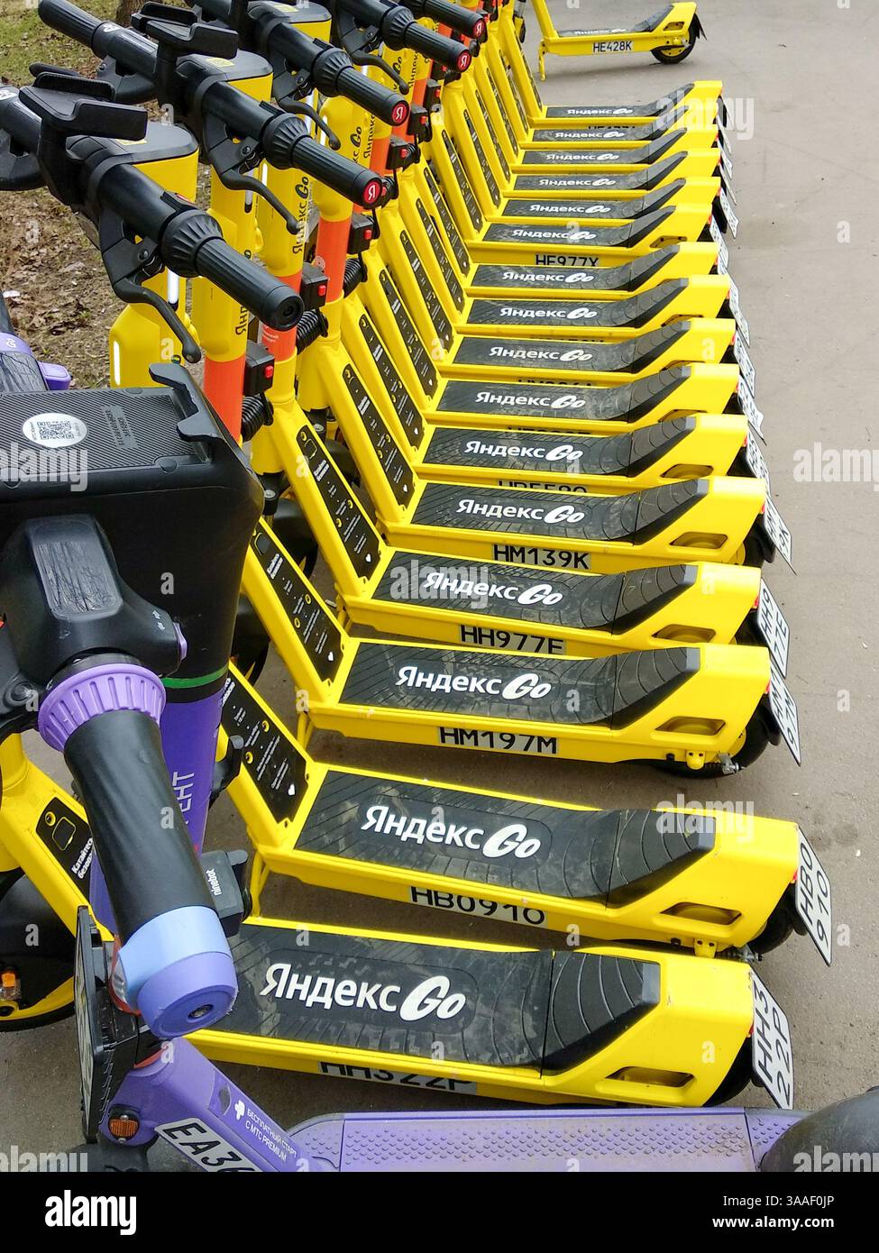 Moskau, Russland - 30. März 2025: Geparkte Elektroroller mit der Angabe des Leasinggebers Yandex Go. Persönliche Mobilitätsausrüstung. Stockfoto
