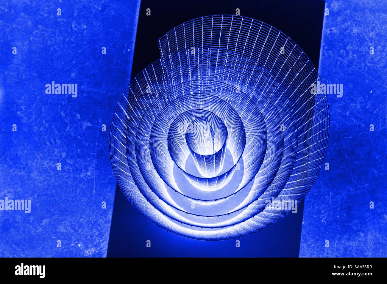 Abstrakte Spirale mit leuchtendem Blau, Flieder, Violett, Violett und Drahtstruktur vor schwarzem Hintergrund, symbolisiert Energie, Bewegung, Industrie und Stockfoto