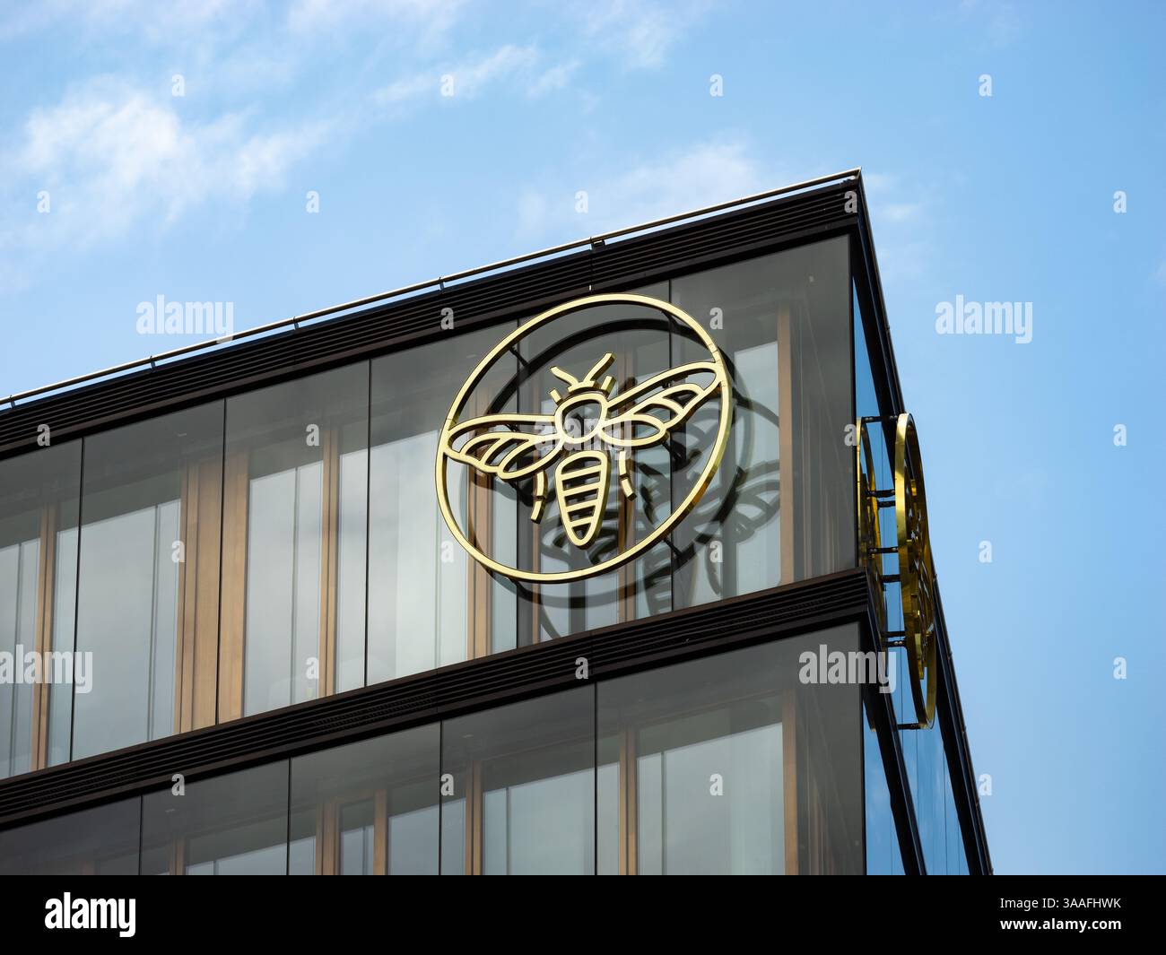 Logozeichen der ERSTEN Stiftung der österreichischen Sparkasse. Bieneninsekt im Kreis an der Fassade eines Bürogebäudes. Nahaufnahme des Symbols. Stockfoto