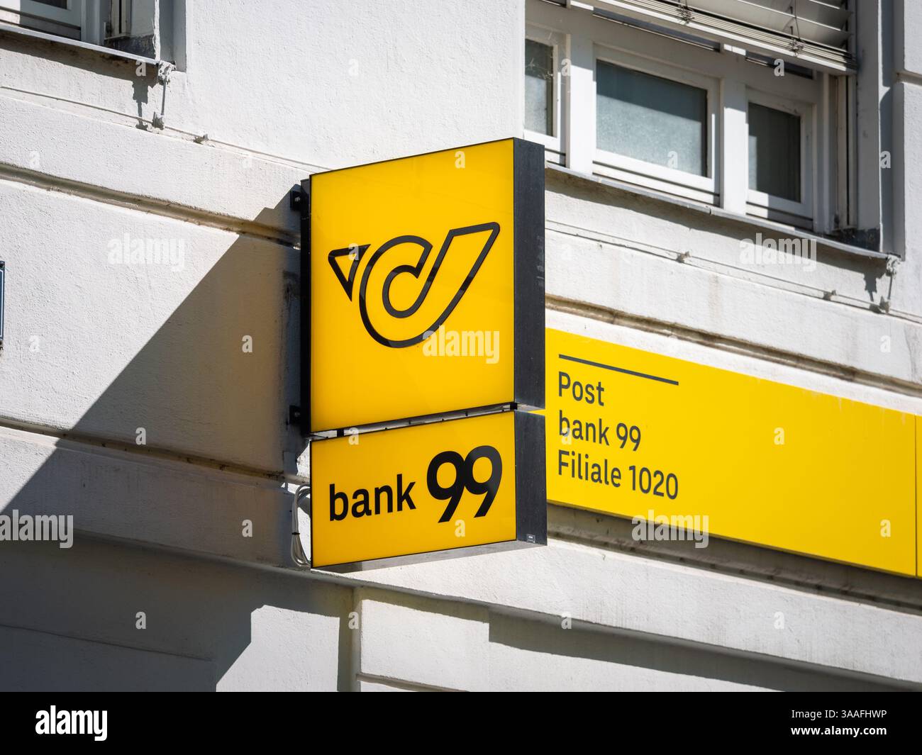 Bank99-Logo der österreichischen Bank. Eine Niederlassung in der Stadt Wien. Gelbes Symbol des Pfostenhorns, das als Werbung an einer Gebäudefassade angebracht ist. Stockfoto
