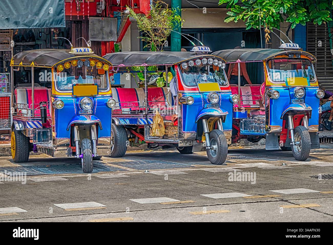 Tuk Tuks in einer Bangkok Straße warten auf Geschäfte Stockfoto