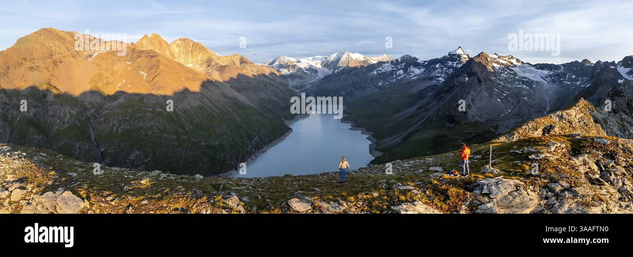 Wanderer genießen das Alpenpanorama am Lac de Dix, Sonnenuntergang in den Bergen, Stausee, Walliser Alpen, Walliser, Schweiz, Europa Stockfoto