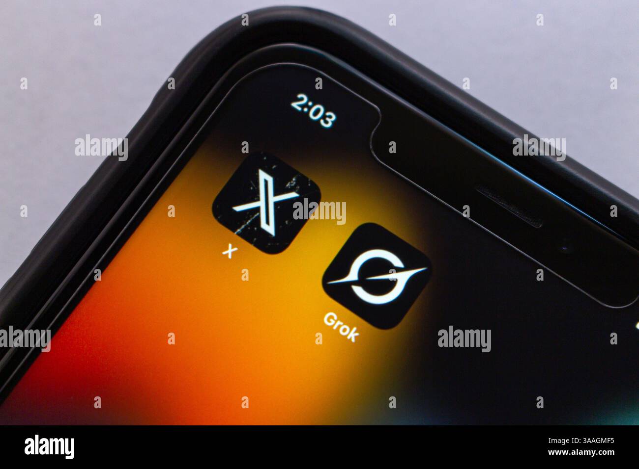 Die X-App und Grok werden auf einem iPhone-Bildschirm angezeigt und veranschaulichen Elon Musks XAI-Übernahme der sozialen Plattform, die früher als Twitter bekannt war. Stockfoto