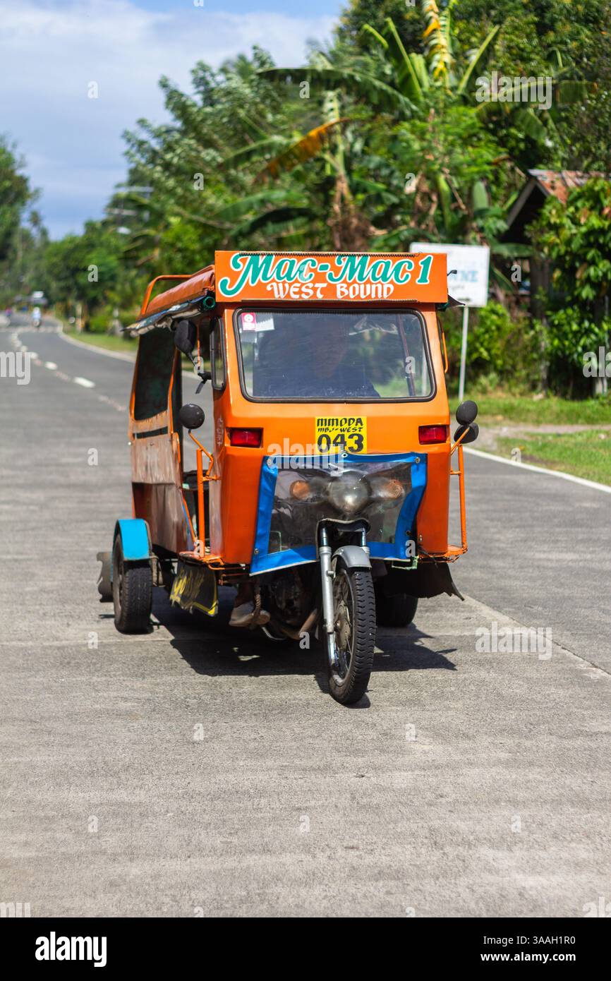 Beliebte Pendlerfahrzeuge, die lokal Motorela genannt werden, auf der Straße auf Camiguin Island auf den Philippinen, die von Einheimischen für alltägliche Reisen genutzt werden Stockfoto