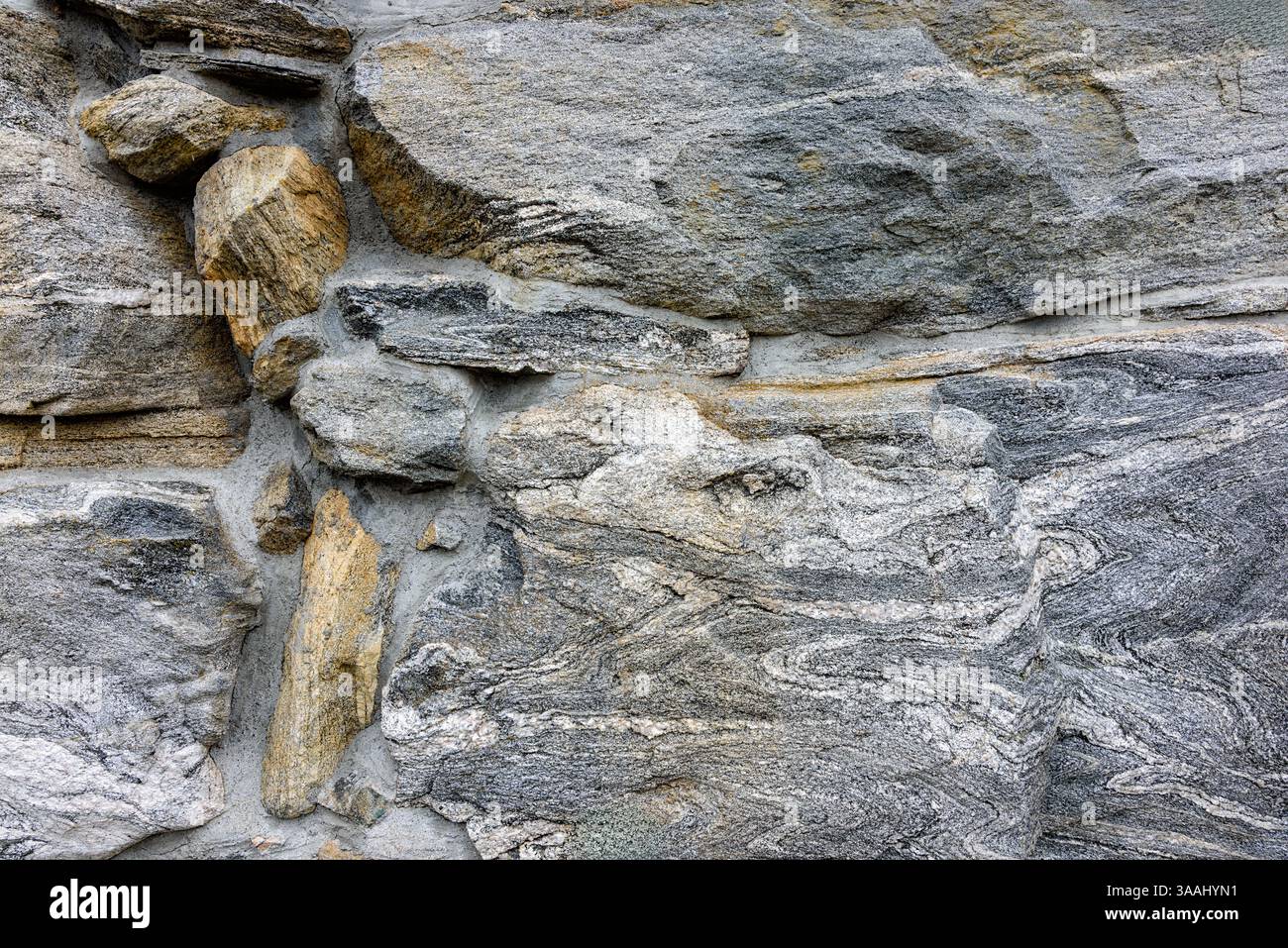 Die strukturierte Felsoberfläche zeigt graue und beige Steine, die natürliche geologische Muster und Formationen im Freien zeigen. Stockfoto