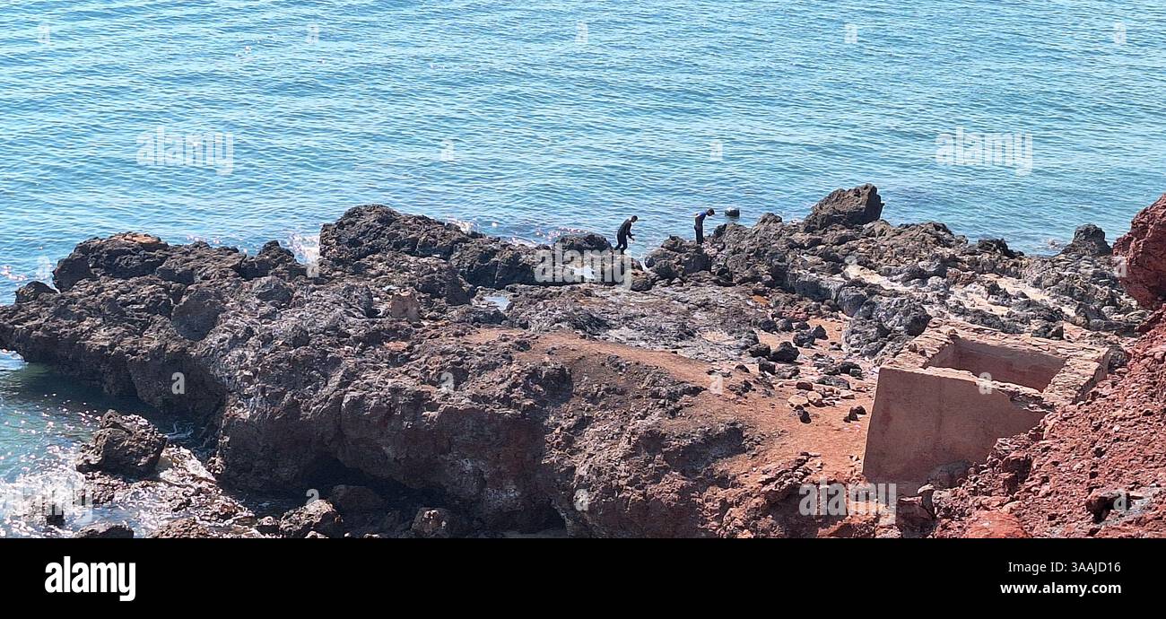 Ein pulsierender Panoramablick fängt den einzigartigen roten Sand und die geologischen Formationen des Roten Strandes auf der Insel Hormuz im Persischen Golf, Iran, ein. Dieser Pop Stockfoto