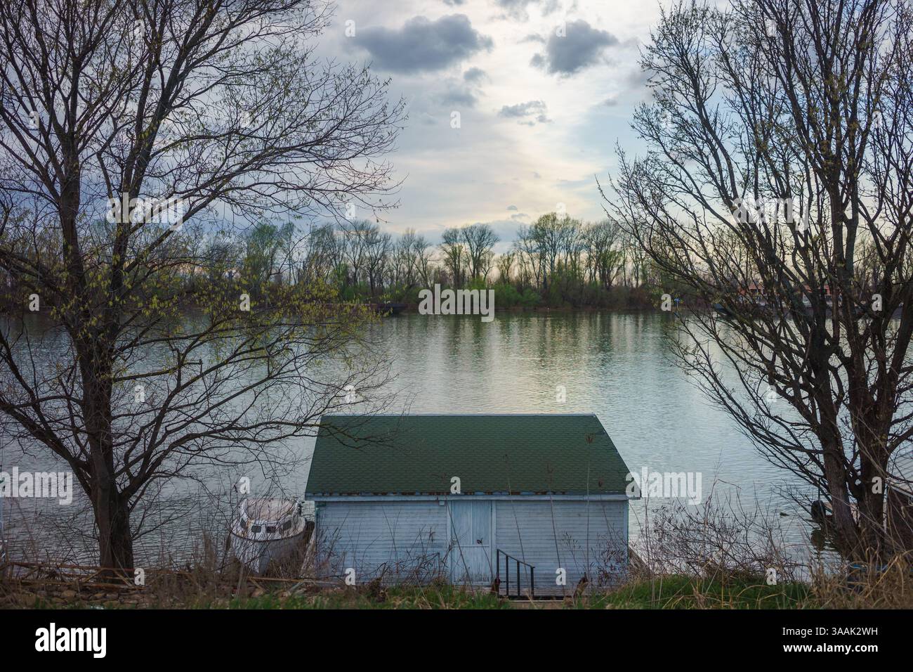 Kleine Holzhäuser am Fluss Sava in Serbien. Früher Frühling, bewölkt, aber schönes Wetter. Stockfoto