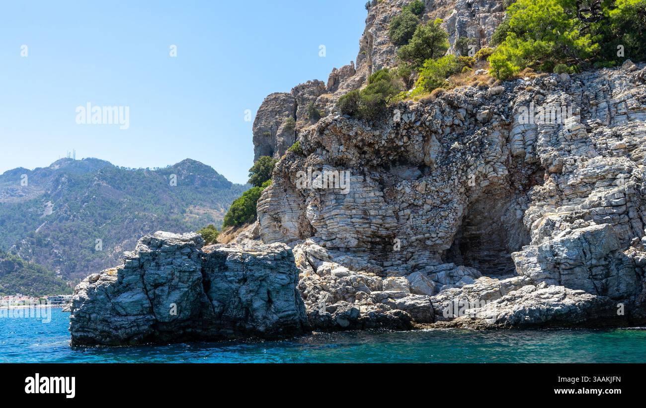 Geschichtete Felsen an der Mittelmeerküste in der Nähe des Dorfes Turunc, Türkei. Bootsausflüge. Aktive Freizeit. Stockfoto