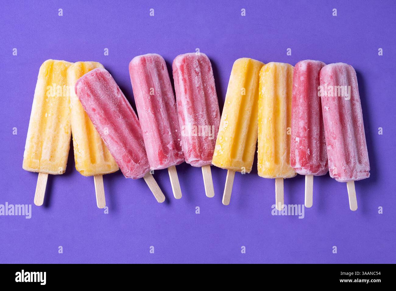 Orange und rosa Eis auf violettem Hintergrund Stockfoto