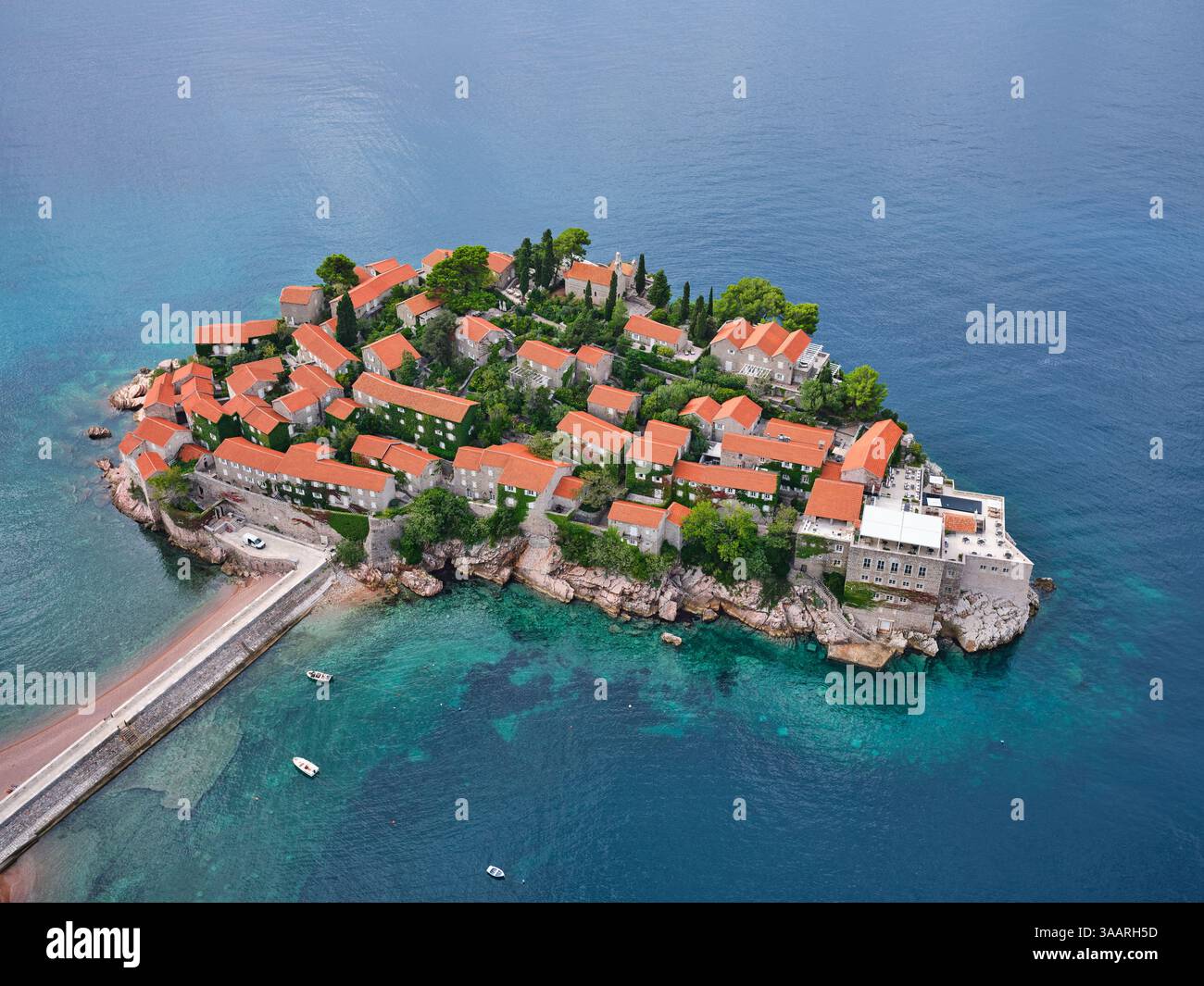 LUFTAUFNAHME. Fünf-Sterne-Hotel auf einer gebundenen Insel, erreichbar durch einen sandigen Tombolo. Sveti Stefan, Montenegro. Stockfoto