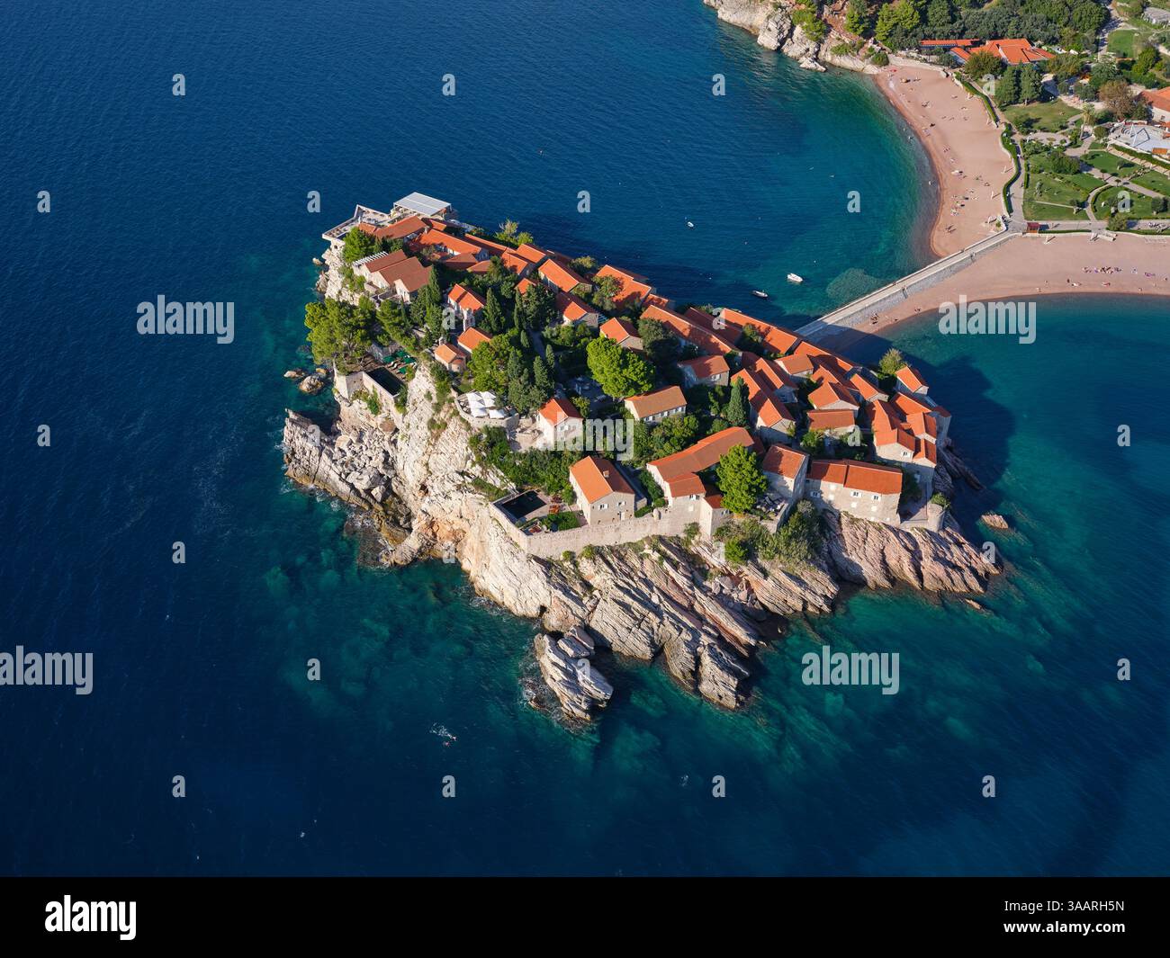 LUFTAUFNAHME. Fünf-Sterne-Hotel auf einer gebundenen Insel, erreichbar durch einen sandigen Tombolo. Sveti Stefan, Montenegro. Stockfoto