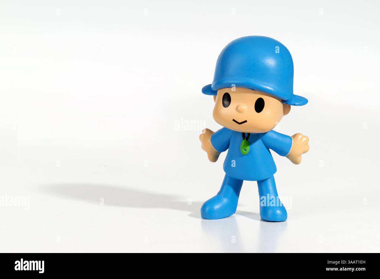 Plastikfigur von Pocoyo, einer beliebten Zeichentrickfigur, die auf einem reflektierenden weißen Hintergrund steht Stockfoto