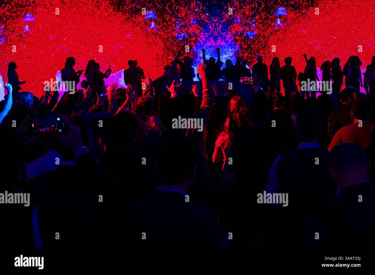 Beim Konzert feiern die Zuschauer und heben die Hände, während der dj auf der Bühne auftritt Stockfoto