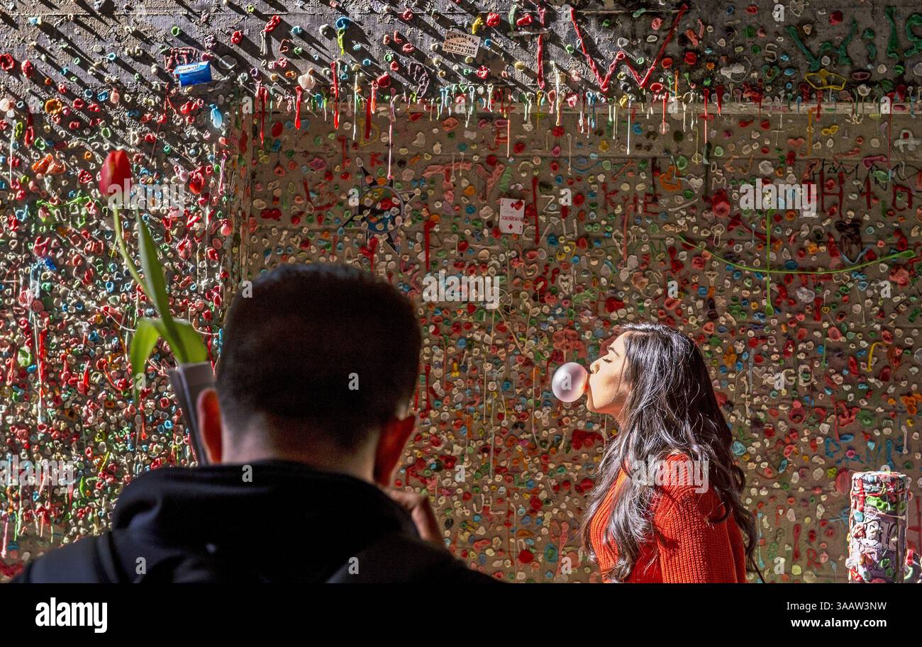 15. März 2018 - Seattle, WA, USA - Julian Pulido fotografiert seine Freundin Mari Berber an der berühmten Touristenattraktion „Gum Wall“ in Seattle, 15. März 2018. Sie kommen aus Kalifornien. (Bild: © Peter Haley/TNS via ZUMA Wire) Stockfoto