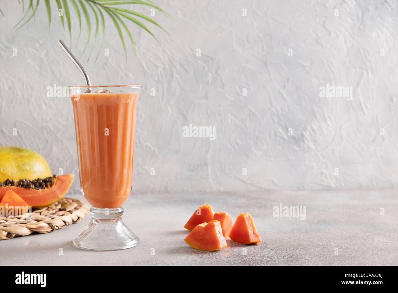 Traditionelles asiatisches Papaya Lassi auf hellgrauem Hintergrund. Frisches kaltes Getränk aus Joghurt, Wasser, Gewürzen, Obst und Eis. Beliebtes Getränk in Stockfoto