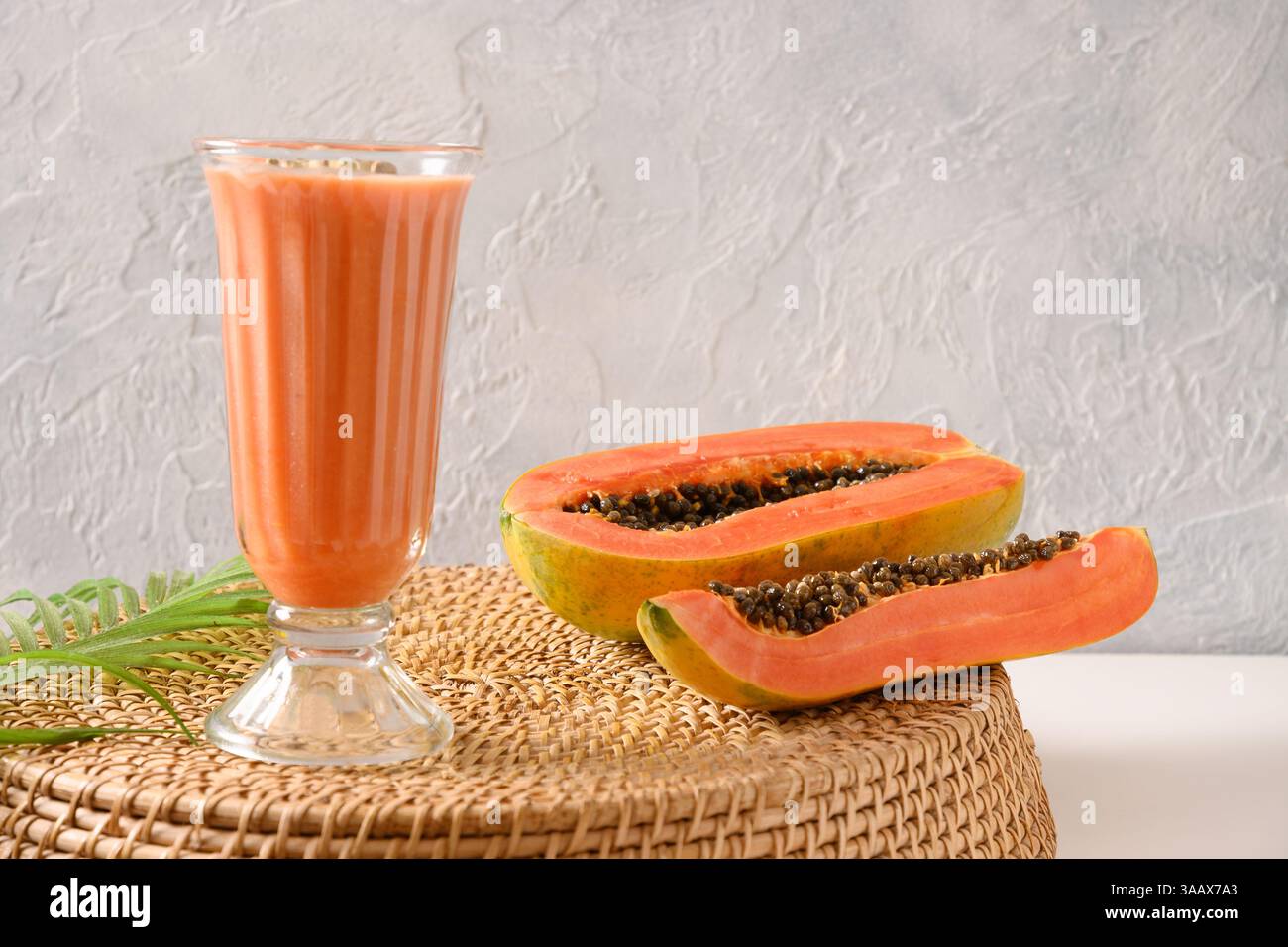 Traditionelles asiatisches Papaya Lassi auf hellgrauem Hintergrund. Frisches kaltes Getränk aus Joghurt, Wasser, Gewürzen, Obst und Eis. Beliebtes Getränk in Stockfoto