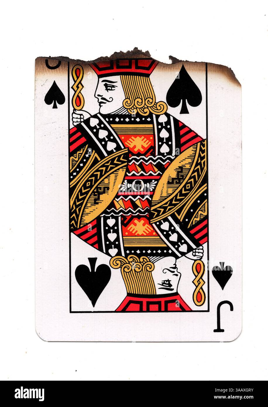 Eine teilweise verbrannte Spielkarte im Pik-Anzug auf weißem Hintergrund. Stockfoto