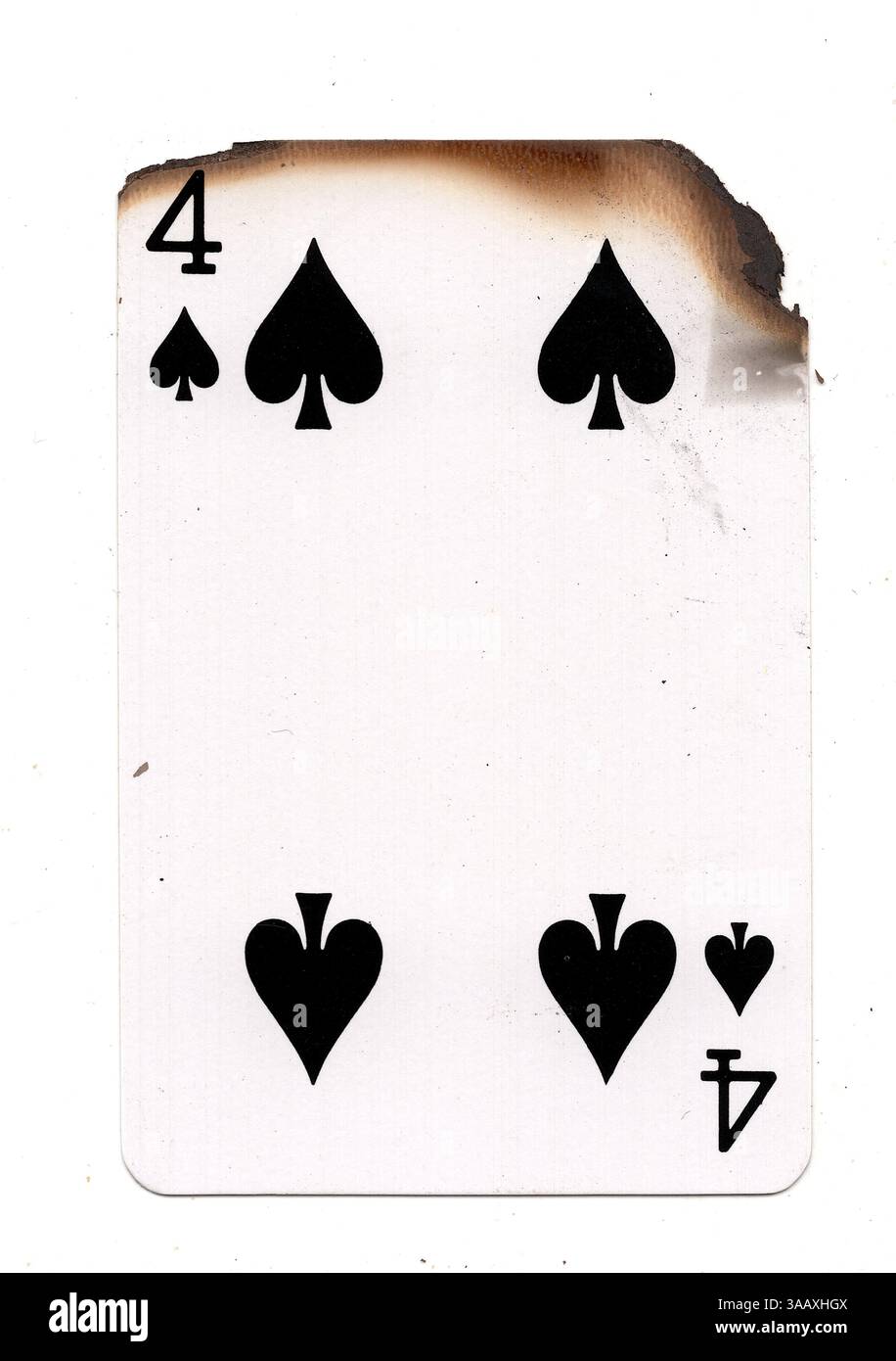 Eine teilweise verbrannte Spielkarte im Pik-Anzug auf weißem Hintergrund. Stockfoto