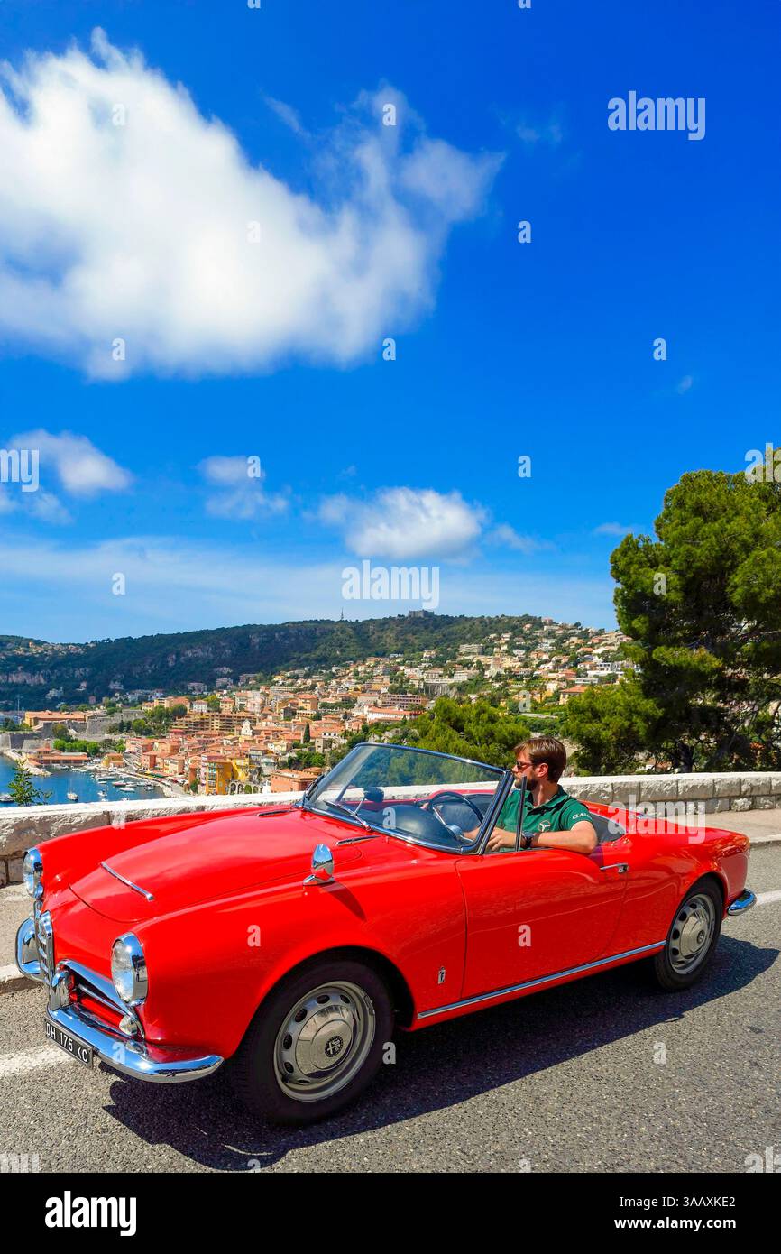 Frankreich, Alpes Maritimes, Villefranche sur Mer, klassisches Alfa Romeo Giulietta Cabrio auf der Basse Corniche Straße mit Blick auf die Stadt (obligatorische Angabe: Firma Rent a Classic Car) Stockfoto