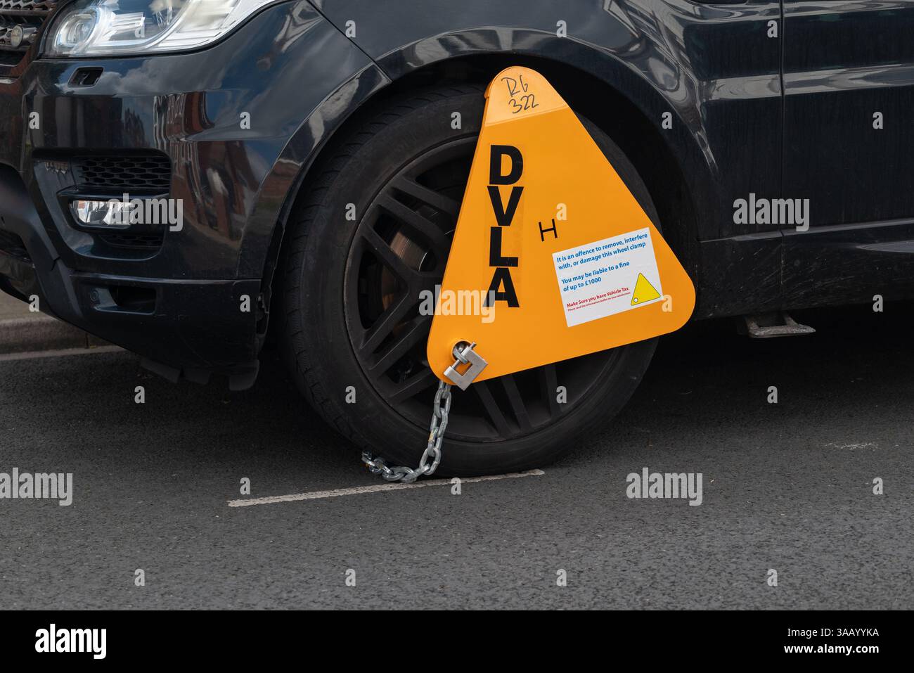 Nicht besteuerte Radklemme an einem Fahrzeug, das von der DVLA deaktiviert wurde. März 2025. Stockfoto